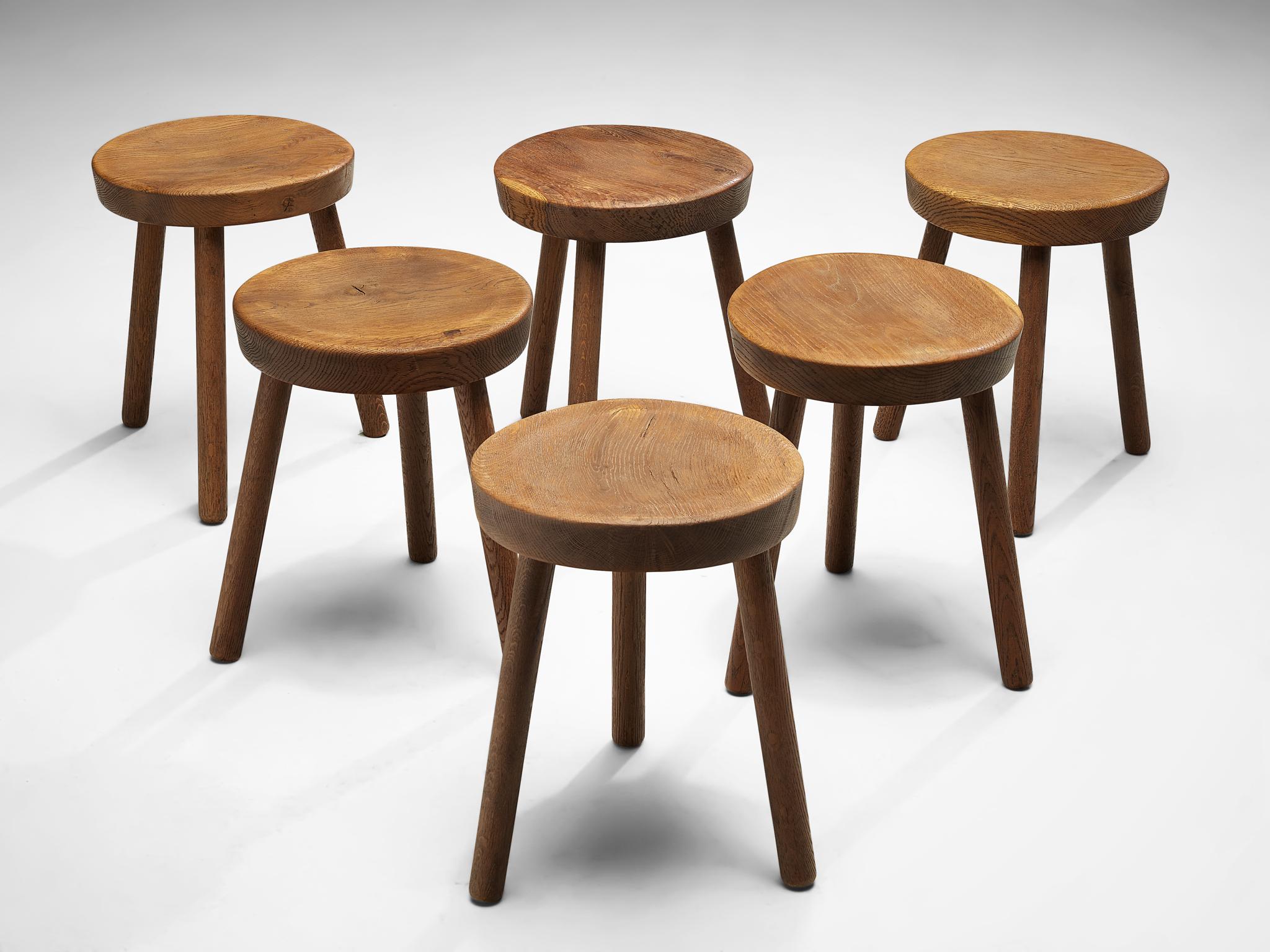 Large set of tripod stools or side tables, solid oak, Switzerland, 1960s-1970s.

Beautiful crafted oak stools originating from the exhibition center in St. Gallen, Switzerland. The seat is handcrafted to have a small dip for better comfort. With