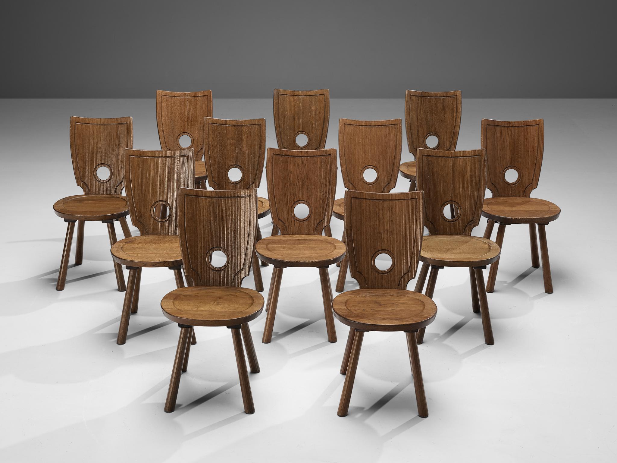 Set of twelve dining chairs, stained oak, brass, metal, France, 1960s

Characteristic set of French dining chairs. In absence of decoration, the rounded gap in the backrest gets an important visual role as it contrasts with the sharp, angular