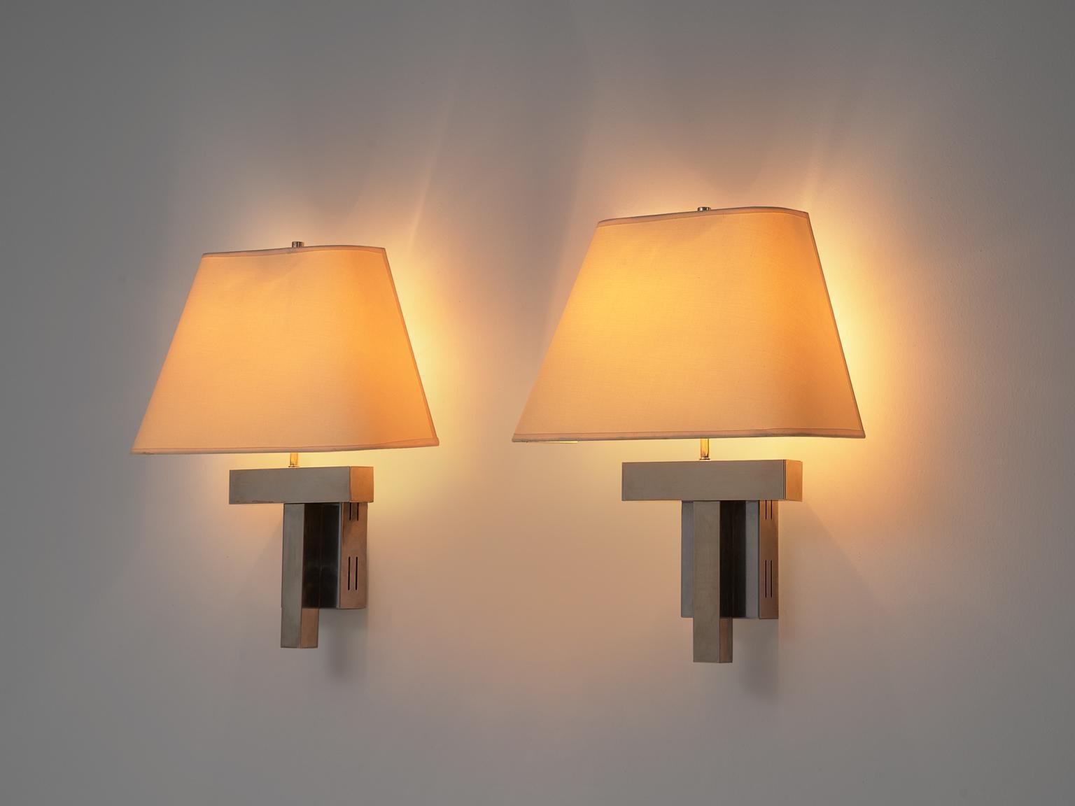 Wall lights, chrome and canvas, Europe, 1970s

This large set of wall-mounted light shades feature a modest design that fits well as extra details in any kind of interior. The cubist frame is made of chromed steel and the shade is made of canvas.