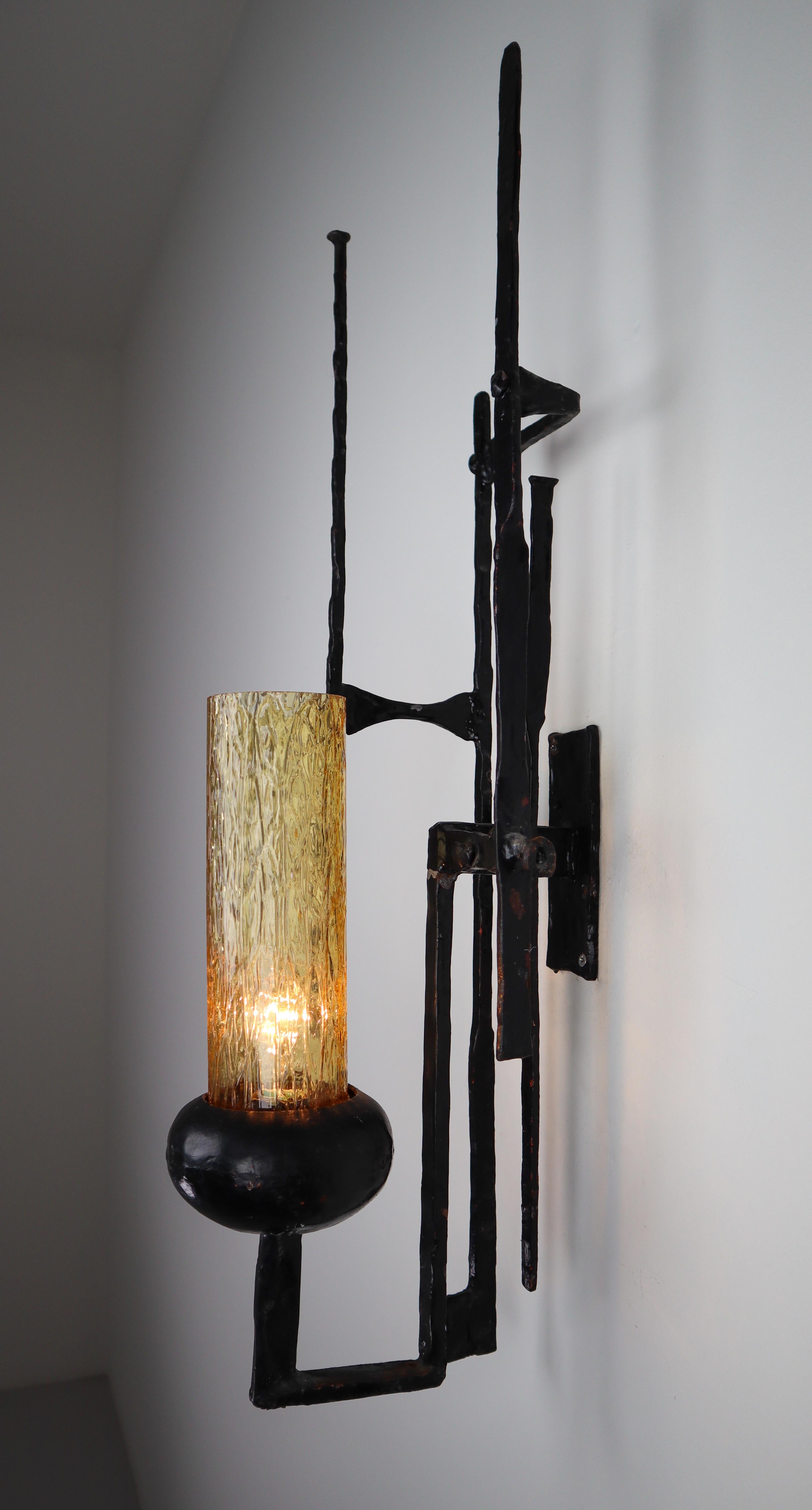 Large set patinated iron and amber color glass Brutalist wall sconces / sculptures, Italy, 1960s. Pure artistic handwrought sculptural frame decorated with amber glass wall lamp/decoration. The pleasant light it spreads is very atmospheric, these