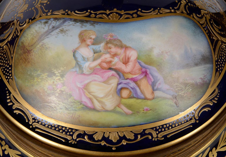 A fine quality late 19th century French Sevres style lidded porcelain comport, having wonderful gilded ormolu finial, handles, mouldings and base. Hand painted romantic scene of lovers to the lid, a floral band of decoration between a cobalt blue