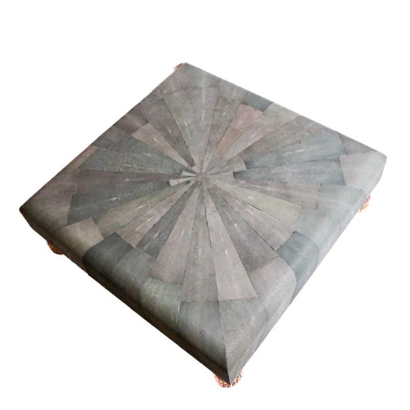 A large shagreen starburst coffee table with gilt feet seamlessly merges sophistication with exotic flair. A piece that can be described as ottoman or coffee table, its expansive surface is wrapped with a stingray skin starburst design, adding a