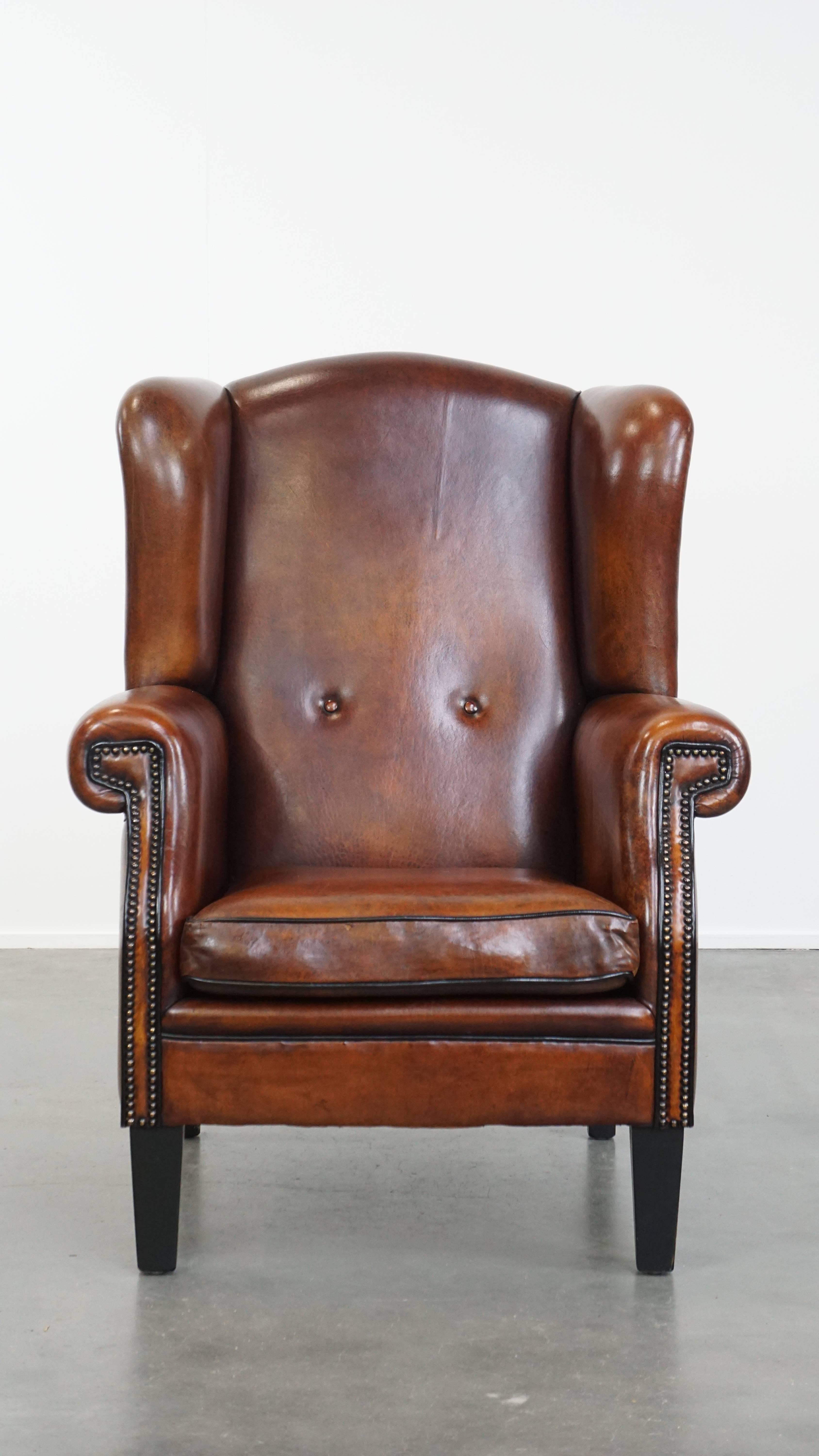 Qui viene offerta questa grande e ben conservata poltrona wingback in pelle di pecora di lusso con profili neri e finiture decorative con chiodi.

Questa imponente sedia a dondolo, realizzata in pelle di pecora, è in buone condizioni e si adatta