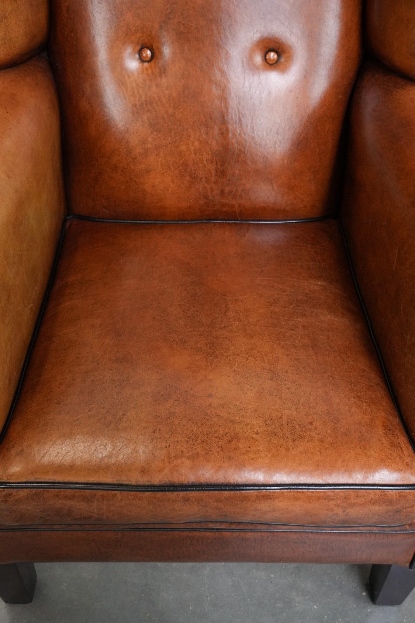 Cuir Grand fauteuil à oreilles en peau de mouton avec passepoil noir et clous décoratifs en vente
