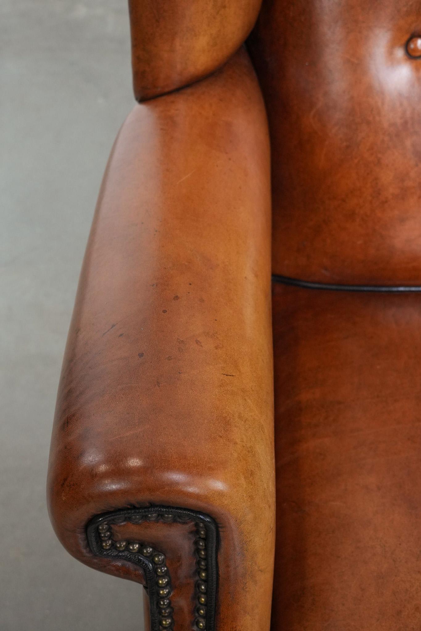 Grand fauteuil à oreilles en peau de mouton avec passepoil noir et clous décoratifs en vente 1