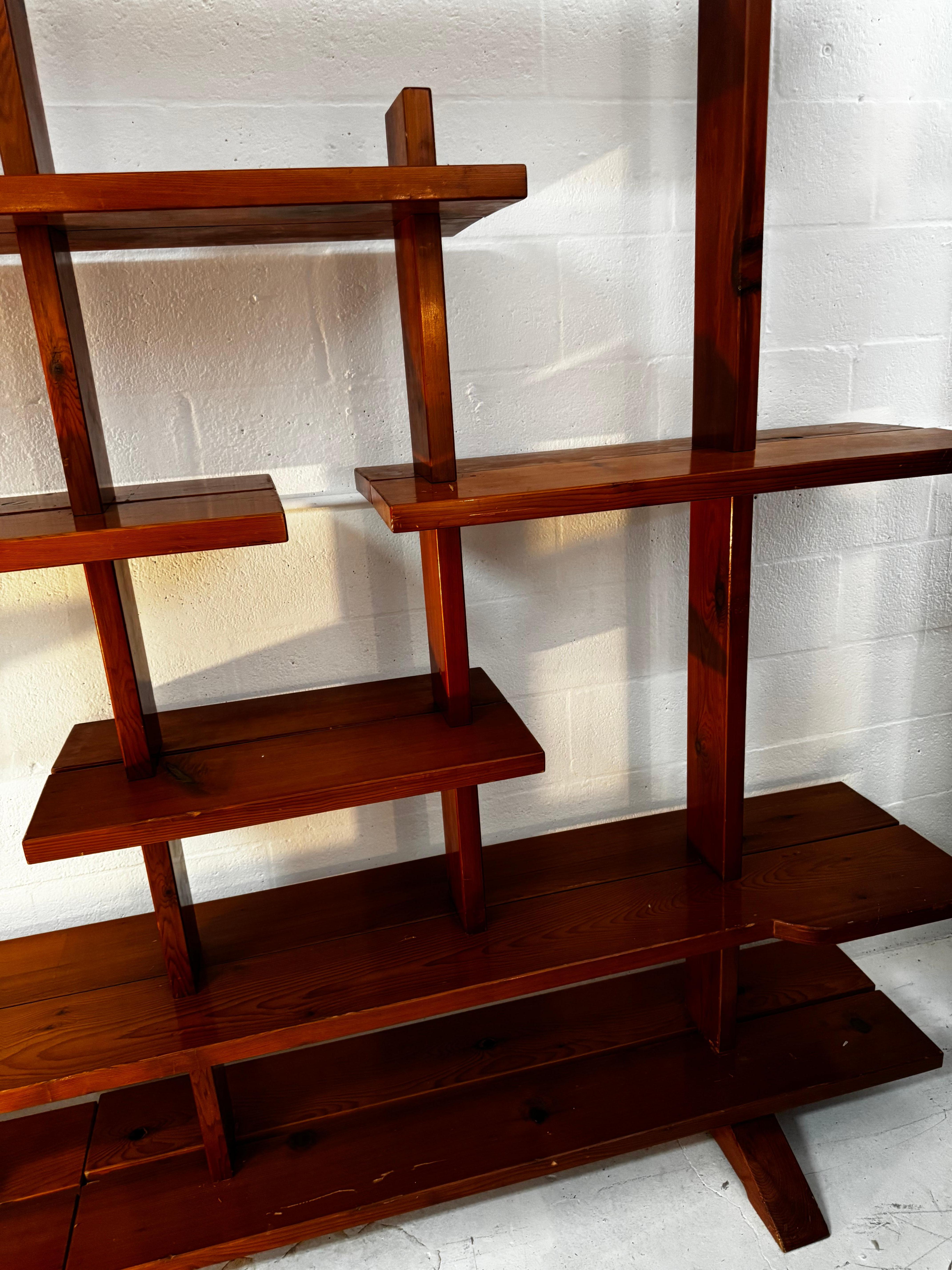 Uno splendido set di scaffali in legno di pino francese, che si estende per ben 3 metri di lunghezza e che emana l'estetica raffinata e funzionale sinonimo dello stile di Charlotte Perriand. Il design presenta linee pulite e minimaliste con