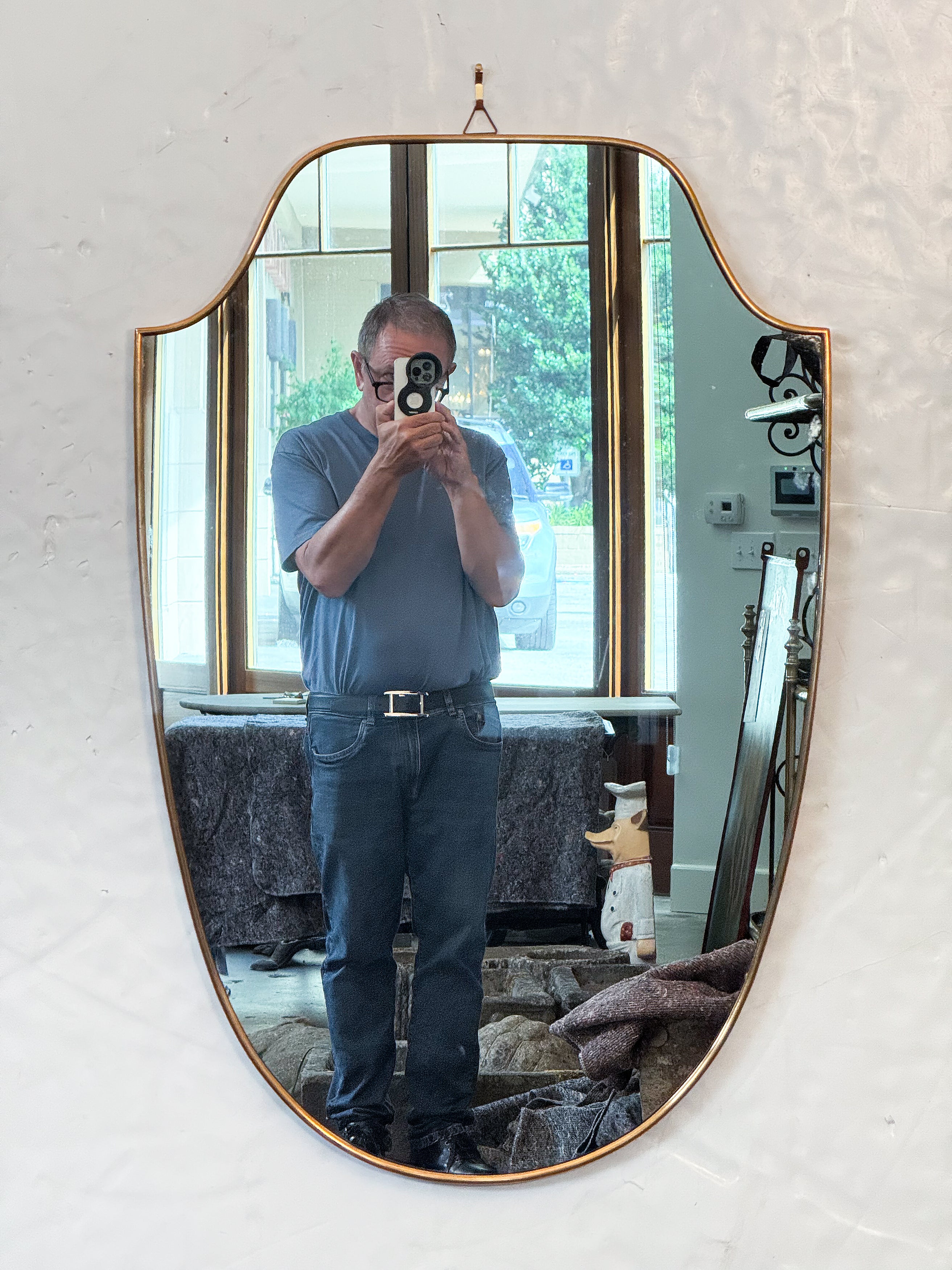 Un grand miroir mural ou d'entrée moderne italien avec un cadre en laiton en forme de bouclier autour de la plaque de verre miroir d'origine.

Dimensions H 35 1/2 pouces x L 23 1/2  pouces x D 7/8 pouces

