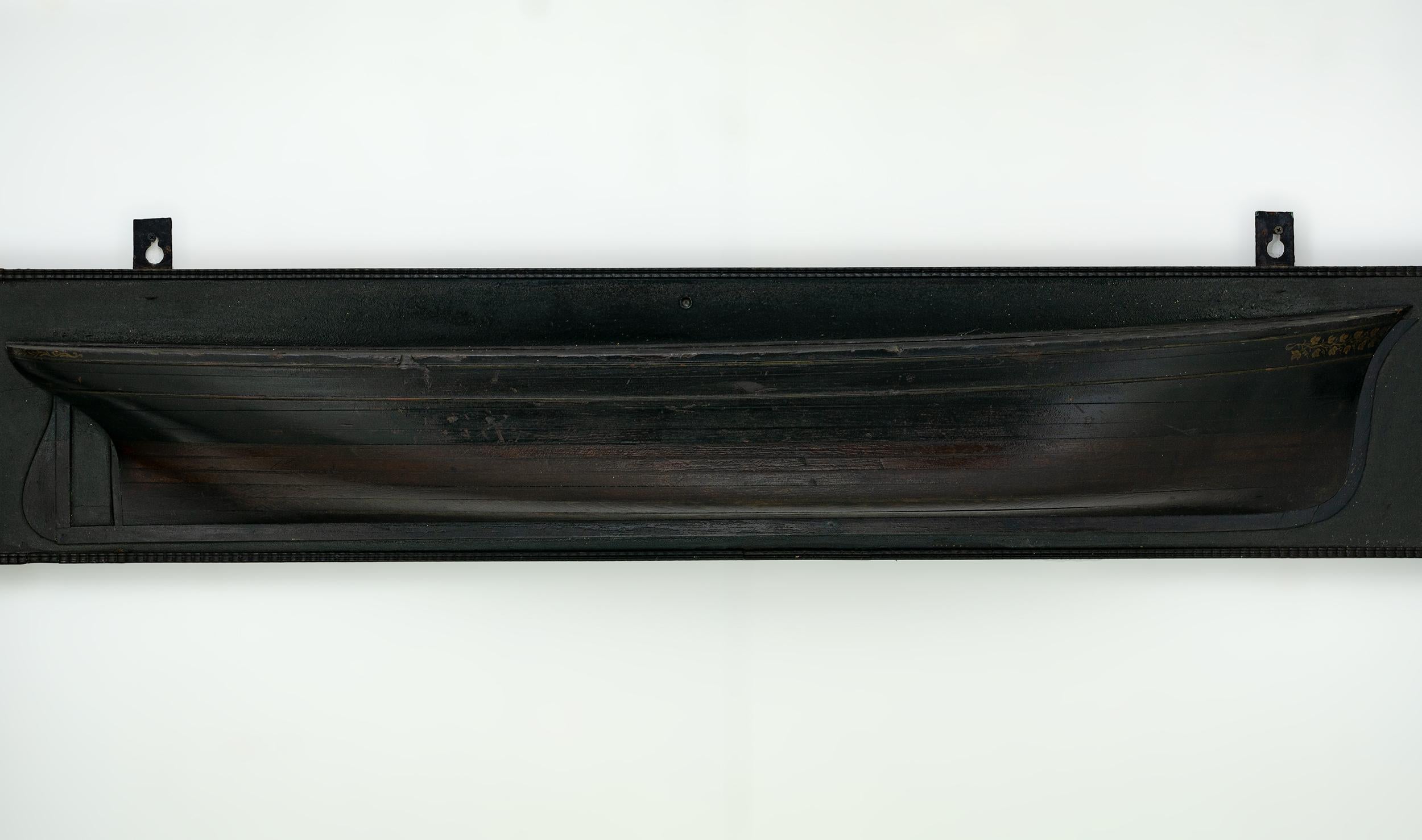 The model is of lift construction painted in black and brown with decorative gilded leaf vinery. Mounted on a black painted backboard with decorative border.
American, circa 1850.