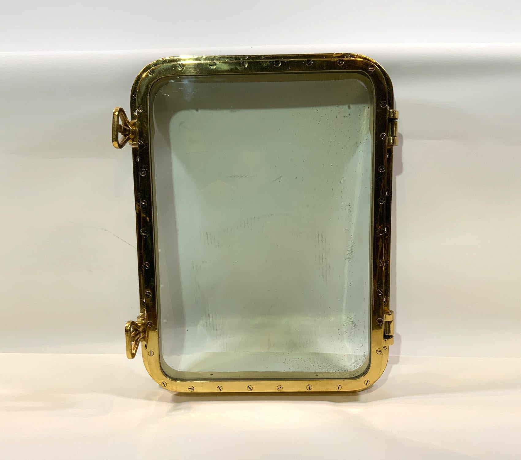 Large highly polished and lacquered ships porthole. First class restoration. Two dog bolts, hinged door. Very heavy.

Weight: 65 LBS
Overall dimensions: 22” H x 29