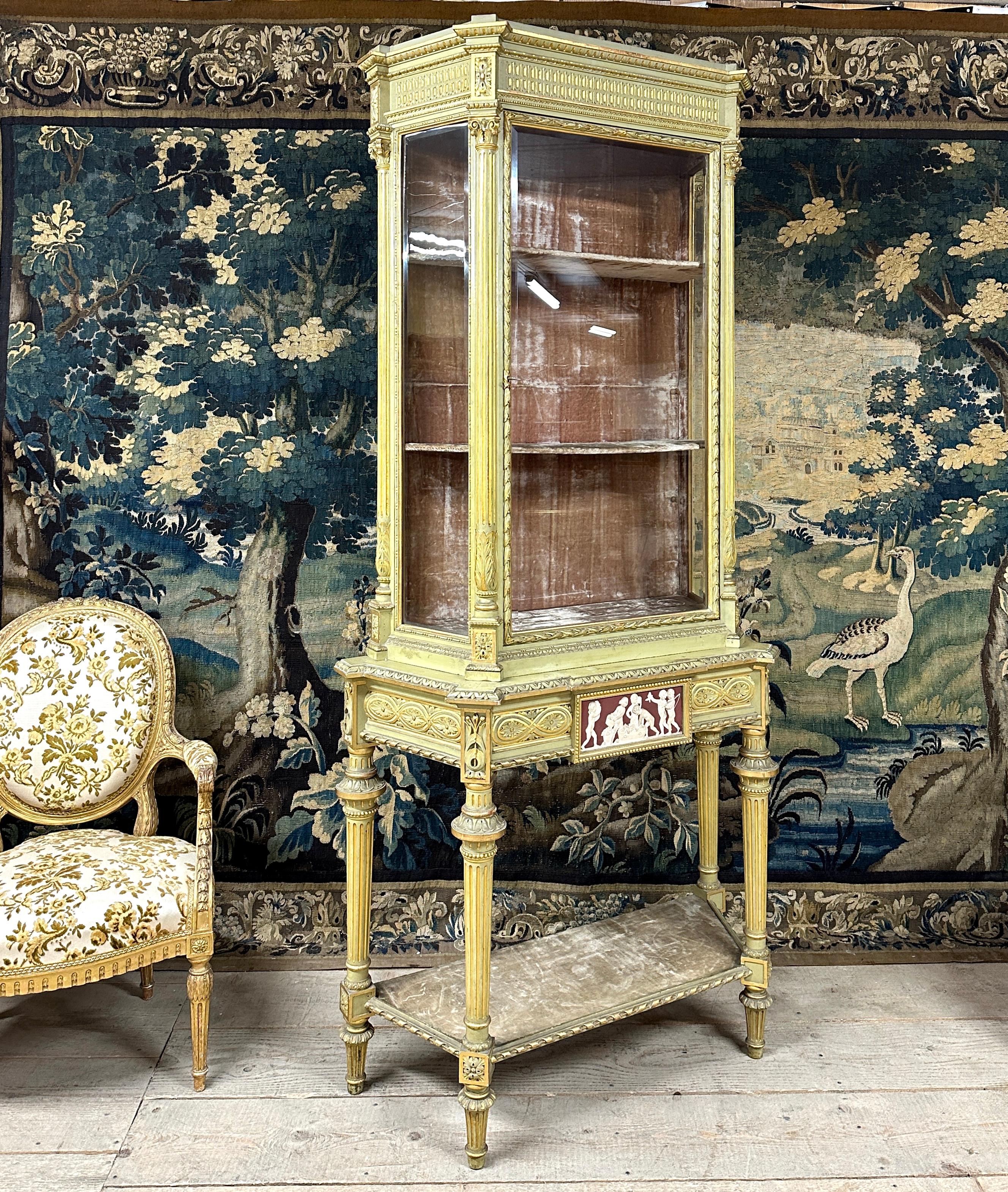 Large two-part Louis XVI style display case in green lacquered wood, gilt trim. Showcase made up of two parts with in the lower part a base decorated with a Wedgwood plaque in the belt, the upper part is glazed on all sides and opens with a central