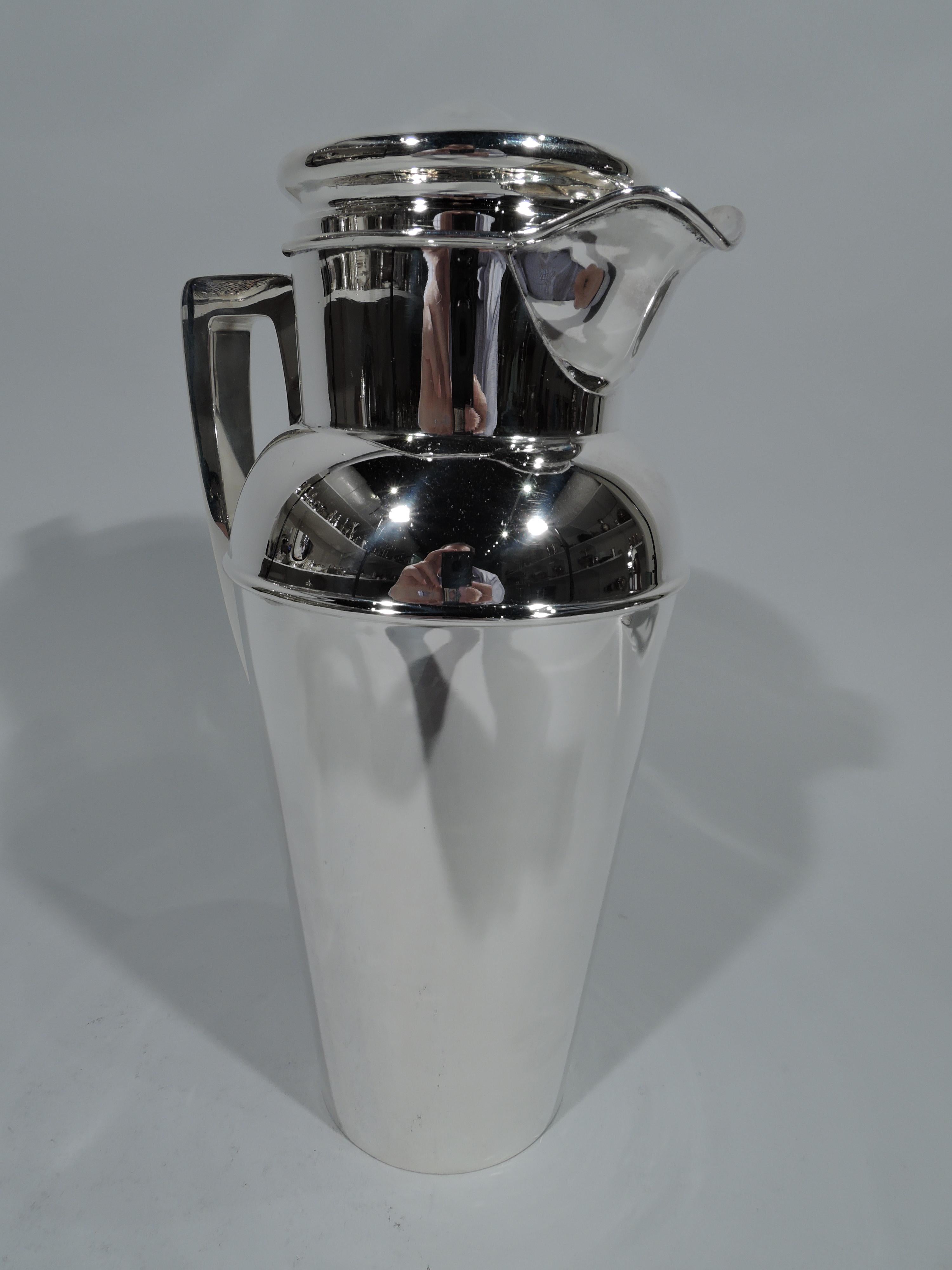 Large Art Deco sterling silver cocktail shaker, circa 1920. Tapering cup, curved shoulder, drum neck, wide lip spout, scroll bracket handle, and raised cover. Neck and cover have built-in strainers. Holds 4 pints. Smart and practical for a