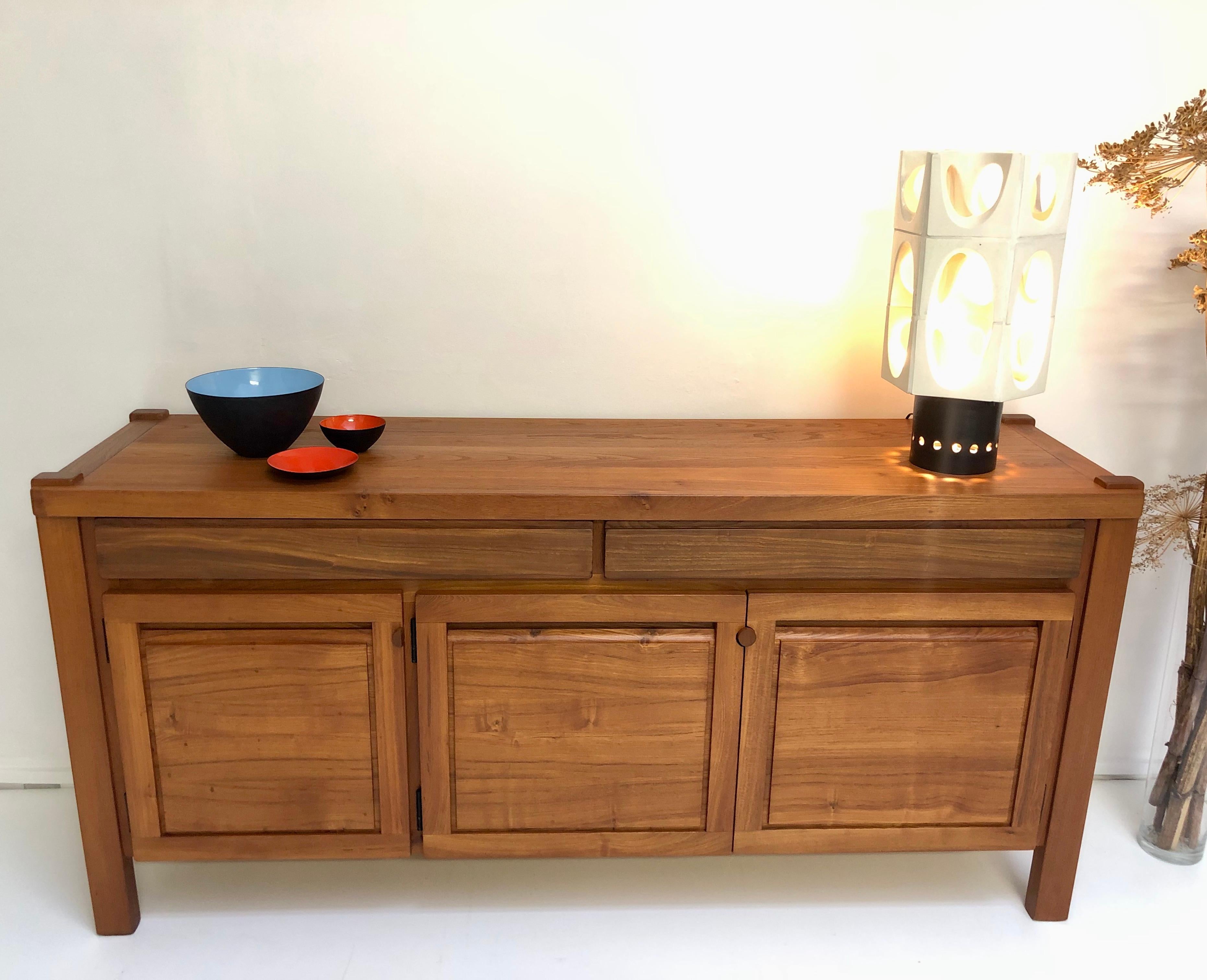 French handcrafted work from the early 1980s, this large buffet combines rusticity and modernity by the essence of warm wood, its minimalist lines and its large storage capacity.

Both massive and design like the creations of Pierre Chapo, it will