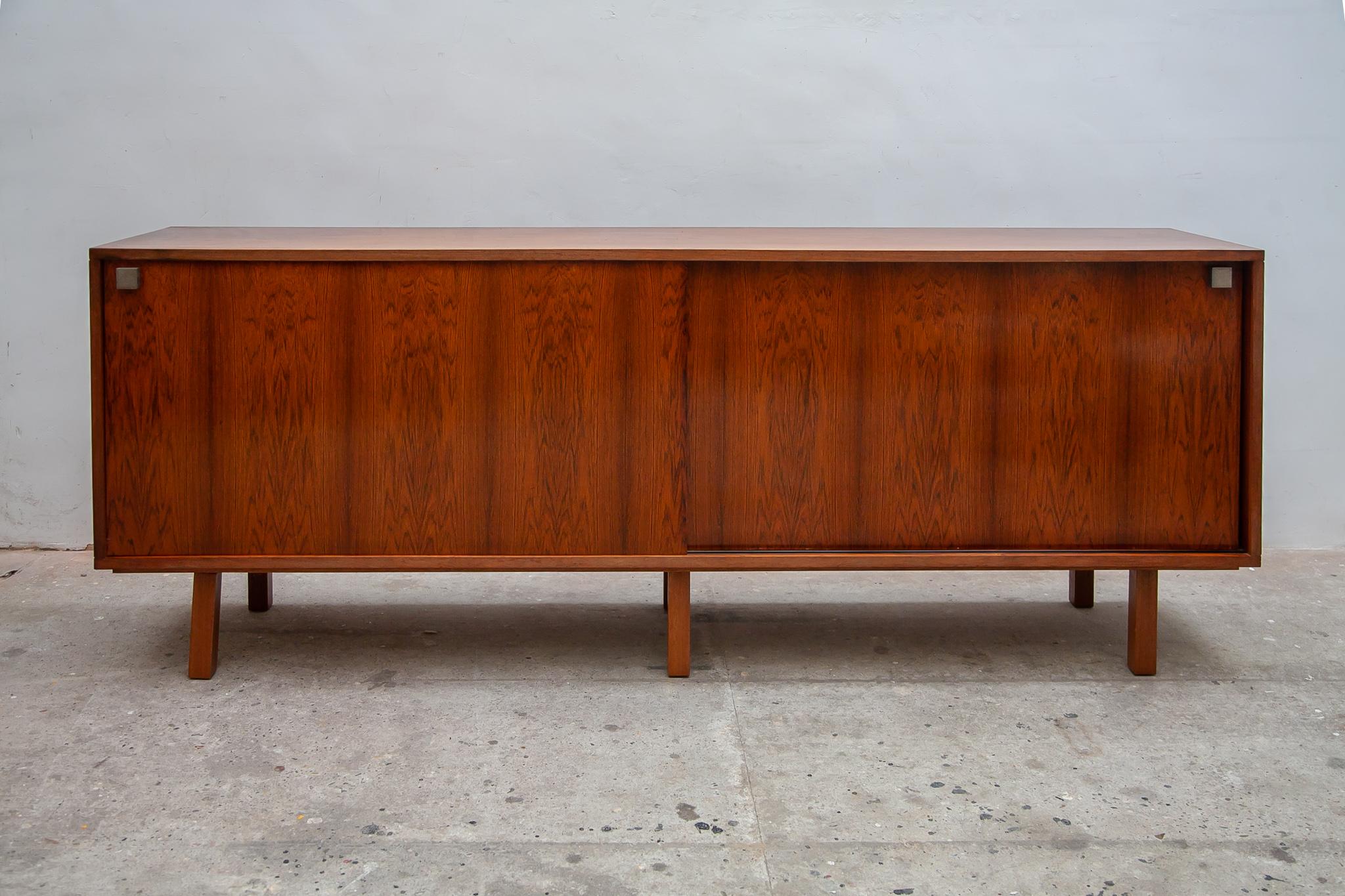 Minimalist sideboard by Alfred Hendrickx for Belform, Belgium 1960s. This sideboard, credenza features the original legs in wood and doorhandles in brushed steel with 2 sliding doors, interior 2 large shelves and 2 drawers it's a design pure sang