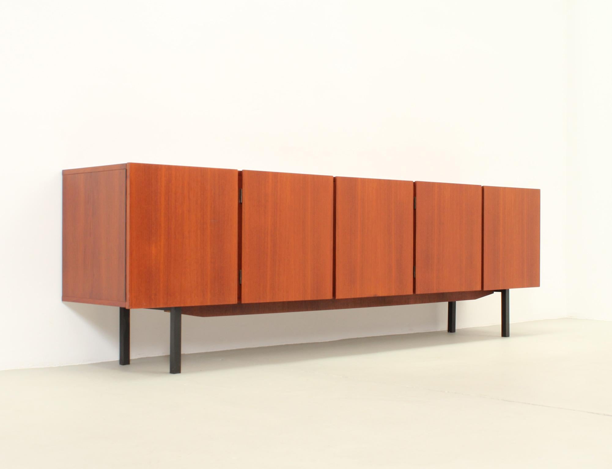 Large sideboard in teak wood from 1960's, Germany. Teak and maple wood with black metal base. Five doors, one with two drawers and an open space and the others with double storage spaces with shelves.