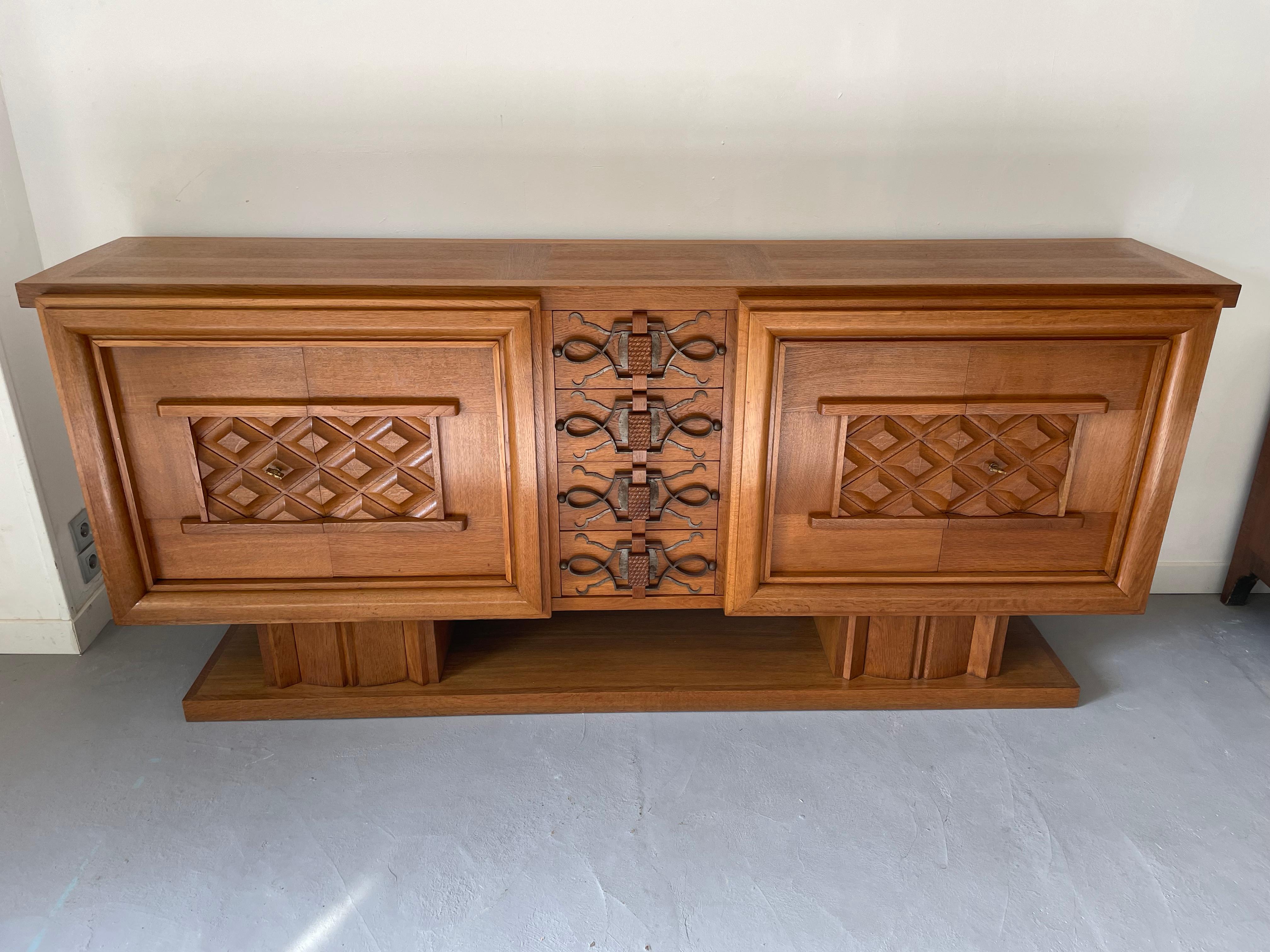 Large sideboard of oak. Front with four doors (one shelf on each part) and four drawers, on which ornaments and handles of iron.