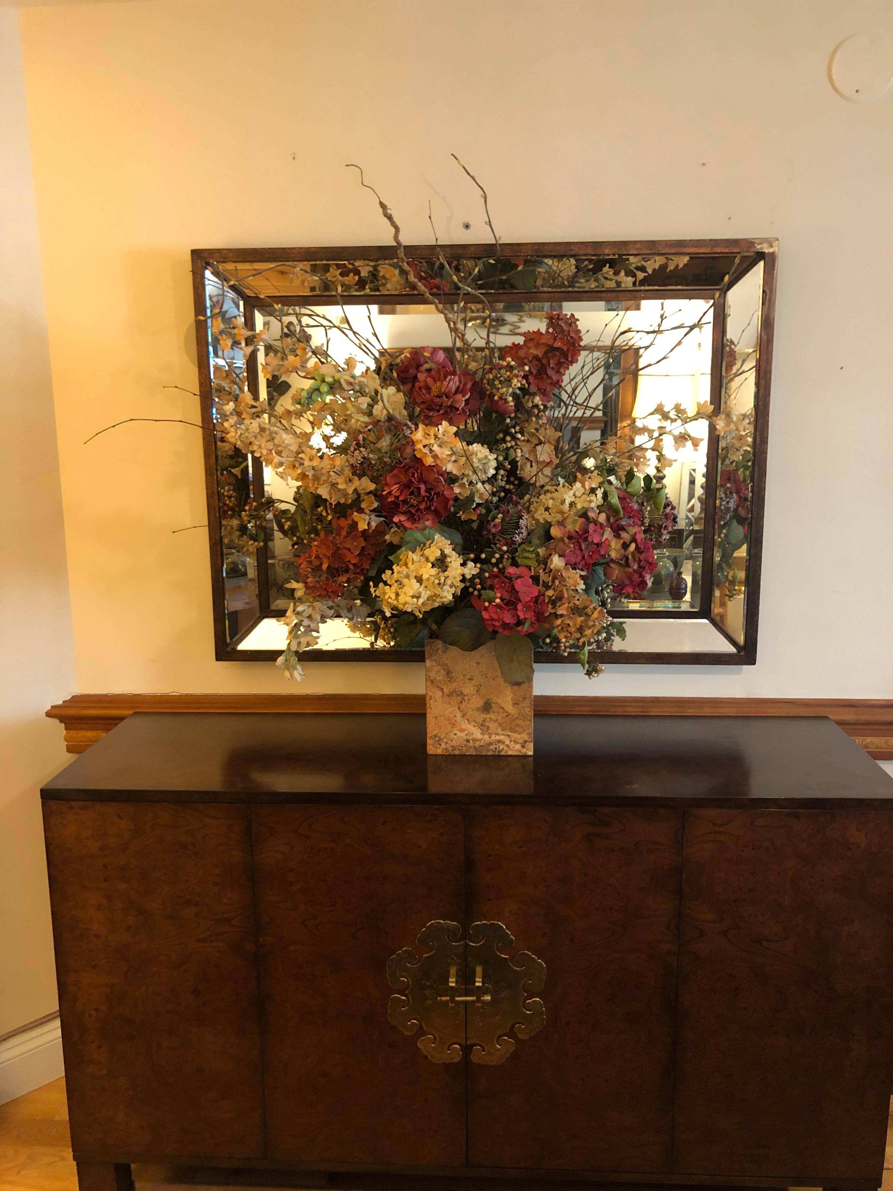 Large silk flower arrangement in a mate finish marble or travertine base. Professionally done with a  palette of soft muted reds and rose colored flowers with green leaves and thick spiked wooden verticals to give it texture. This arrangement will