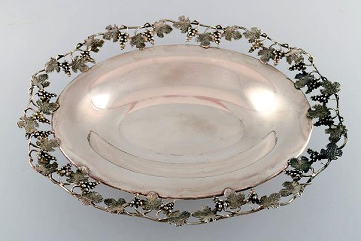Large silver bowl pierced with grape vines.
Measures: 36 cm x 29 cm x 8 cm high.
In perfect condition.
Signed illegible.