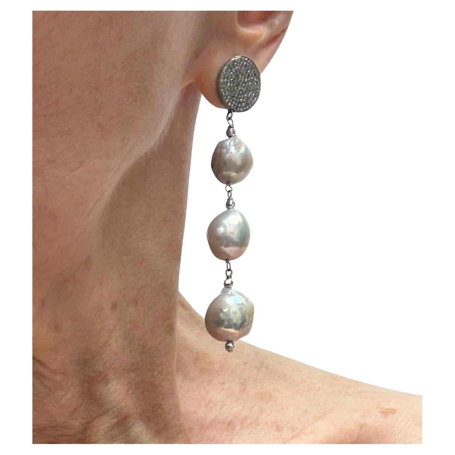 Descrizione
Grandi perle d'acqua dolce rare nucleate di colore grigio-argento accentate da sfere sfaccettate in oro bianco 14k con pavé di diamanti.
Articolo # E3240
Guarda la collana abbinata, articolo N3658, venduta separatamente.

Materiali e