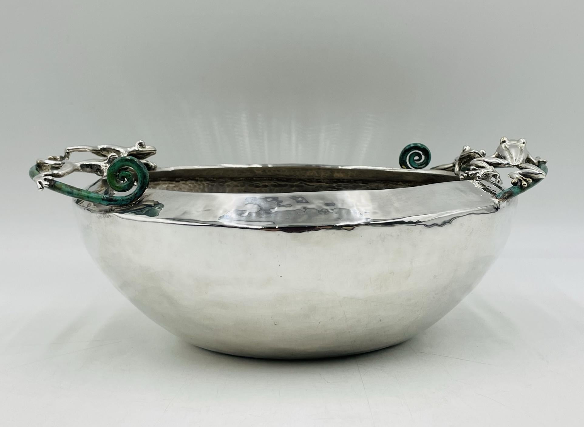 Elevate your dining experience with this exquisite Large Silver-Plated Bowl with Frog Handles by renowned Mexican artist Emilia Castillo. Hand crafted in Taxco Guerrero at the shop of Emilia Castillo by skilled artisans, this stunning piece features
