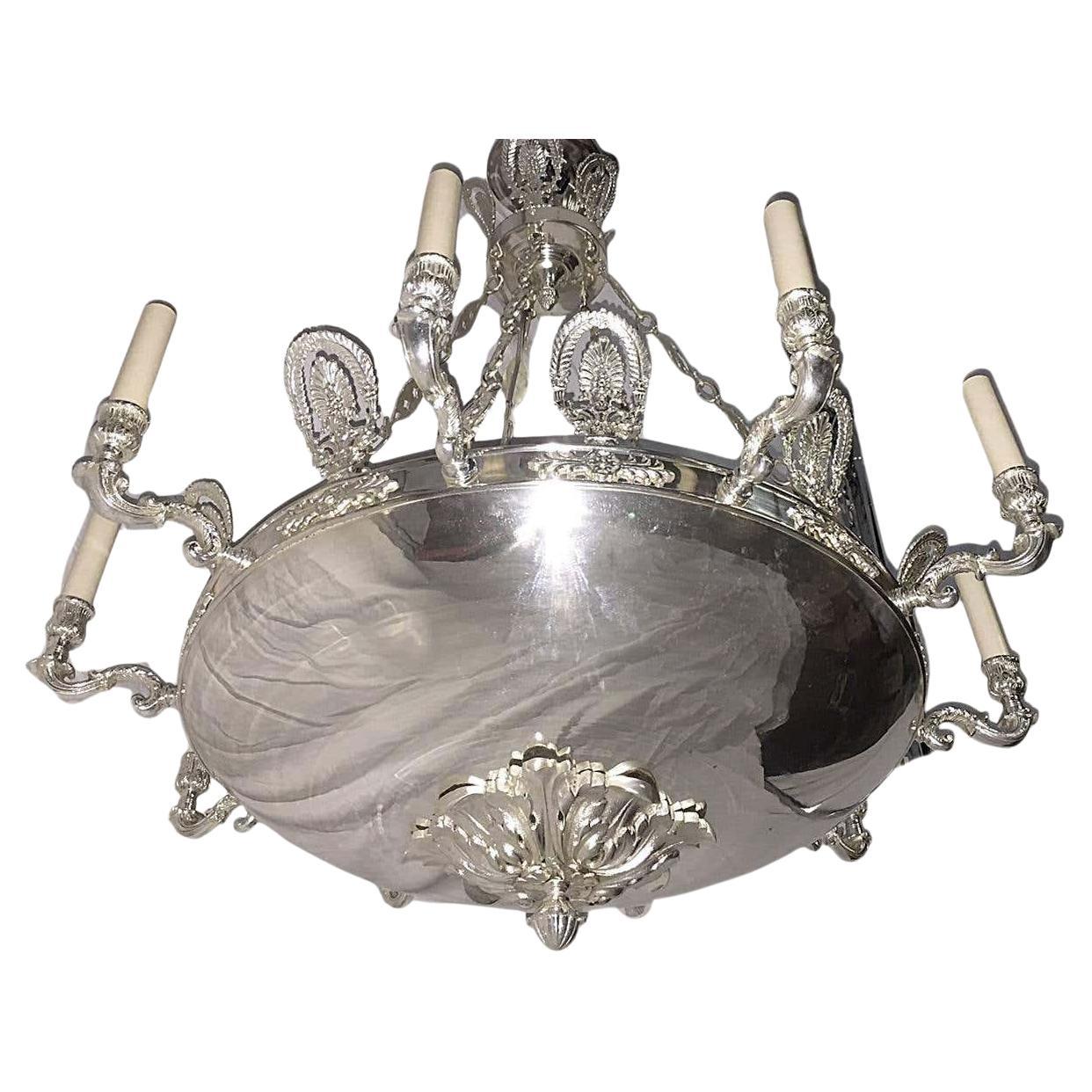 A French Empire-style circa 1920's silver-plated ten-arm chandelier.

Measurements:
Diameter: 32
