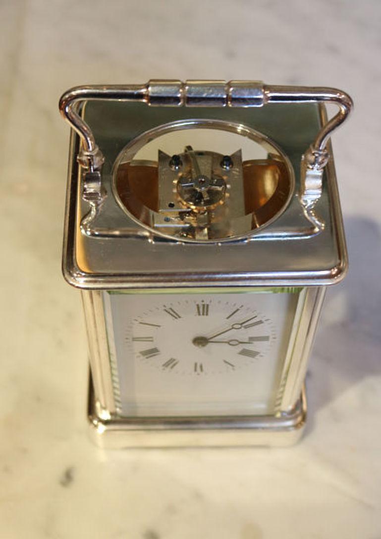 A large silver plated carriage clock, make in the late 19th century. It has a corniche case, with an oval bevel edge top glass, and a clear Roman numeral enamel dial with moon hands. The good quality 8 day movement has its original lever platform.