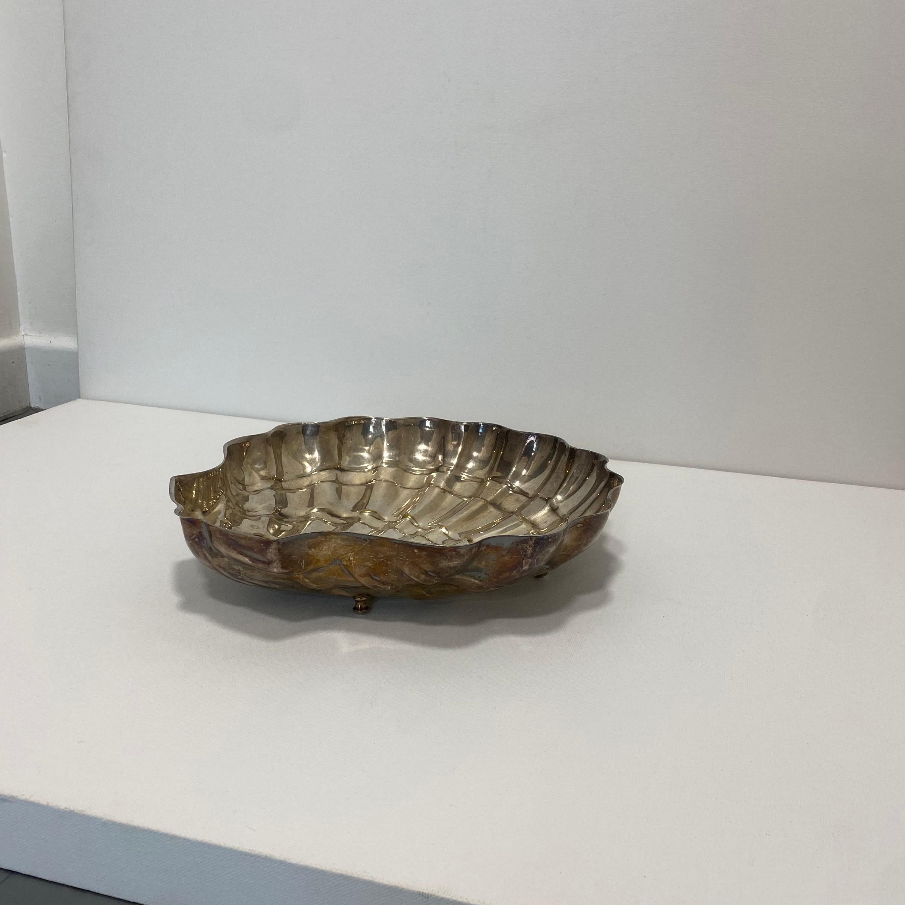 Questa grande ciotola argentata a forma di conchiglia è un suggestivo richiamo a Venere e alle curve organiche della natura. 
Importato dall'Italia degli anni '70, fonde perfettamente le influenze eleganti dell'Art Deco degli anni '40 con il glam di