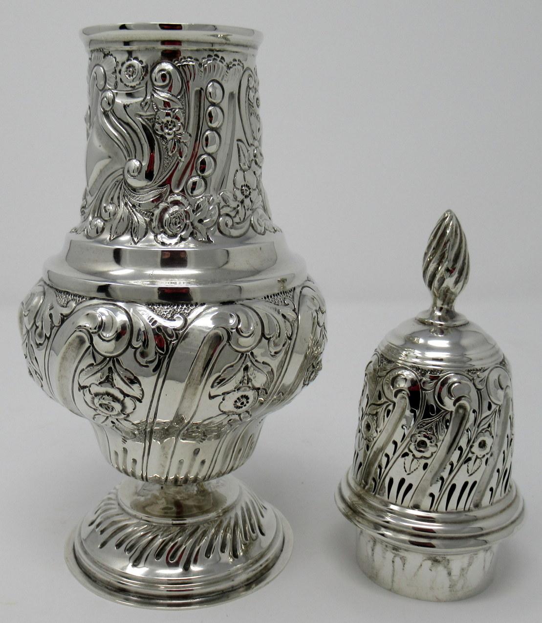 Stunning sterling silver sugar caster of typical baluster form and unusually large size, early 20th century.

The entire embossed with lavish decoration of latticework and scrolls, the pierced pull-off lid with similar decoration and scrolling