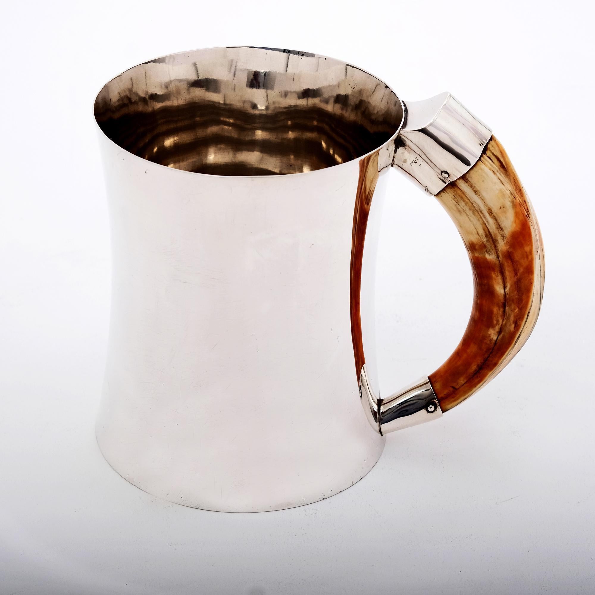 An excellent heavy-gauge silver pint mug with incurved sides and an inset handle probably carved from a wild boar tusk. This stylish piece is very comfortable to hold and drink from.