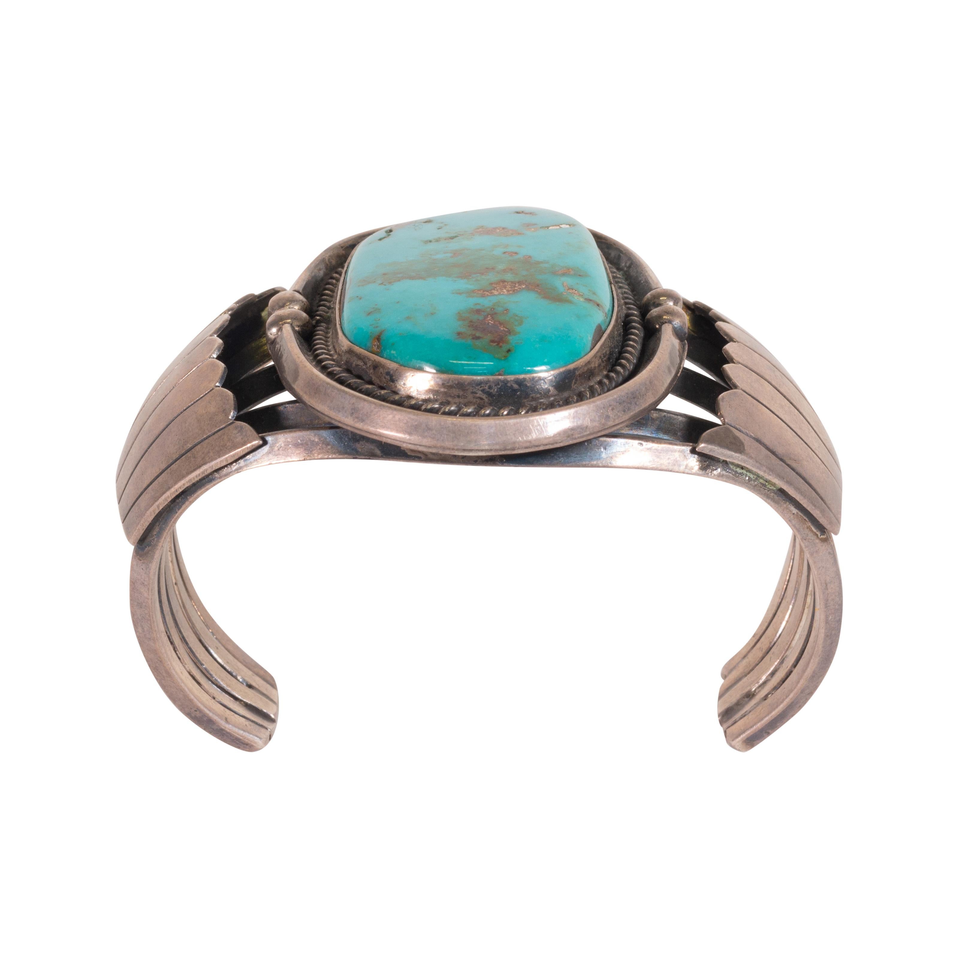 Bracelet manchette en turquoise Cerrillos. Belle pierre centrale entourée d'une bordure de corde, de perles et d'un éventail latéral. La pierre est d'un bleu-vert profond avec des mouchetures d'or et une matrice brune. Pièce exceptionnelle, idéale