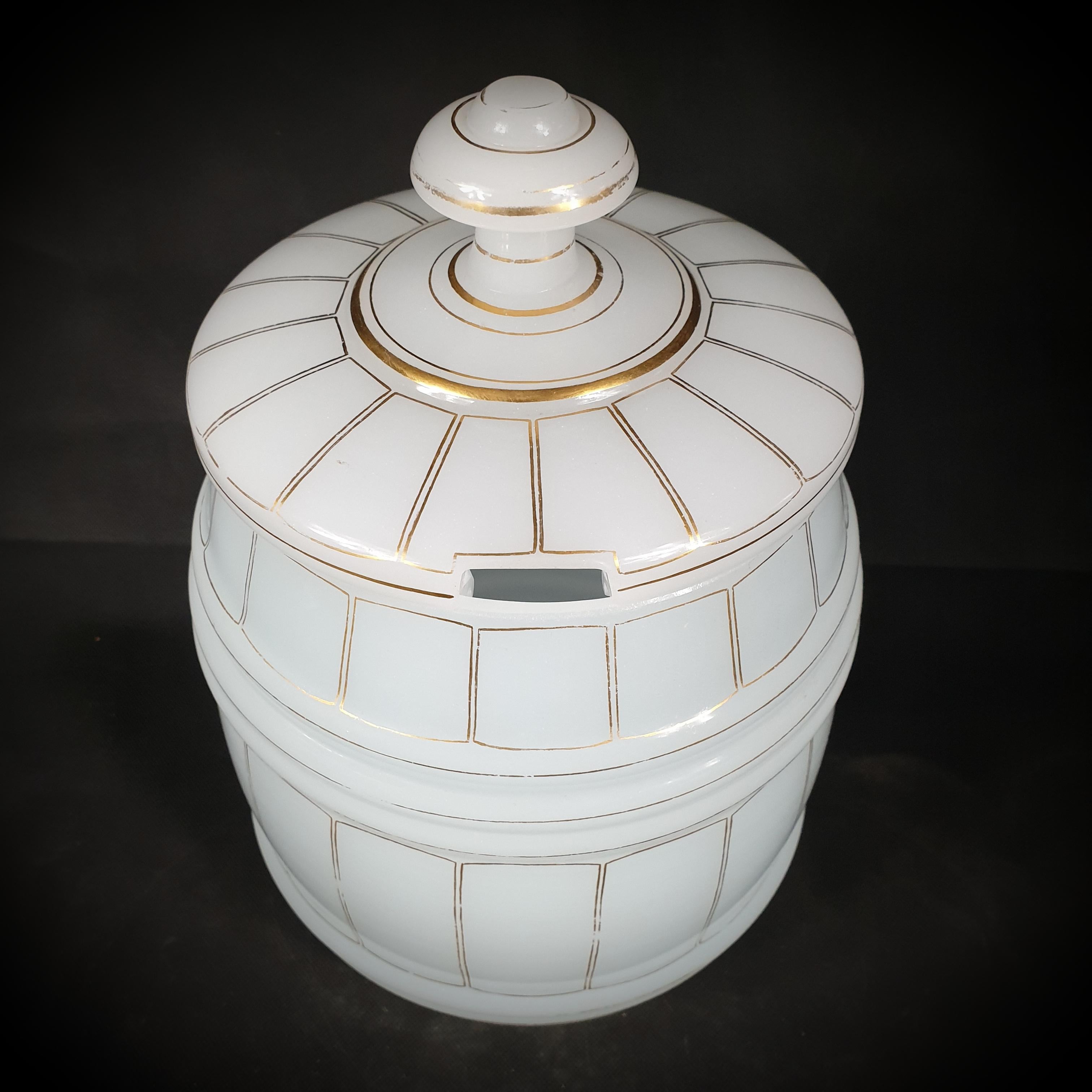 Presented here is a 19th-century French opaline glass jar with a milky white hue. Adorned with intricate gold barrel decorations. Everyone who appreciates antiques would be pleased to add this treasure to their collection. The dimensions are an