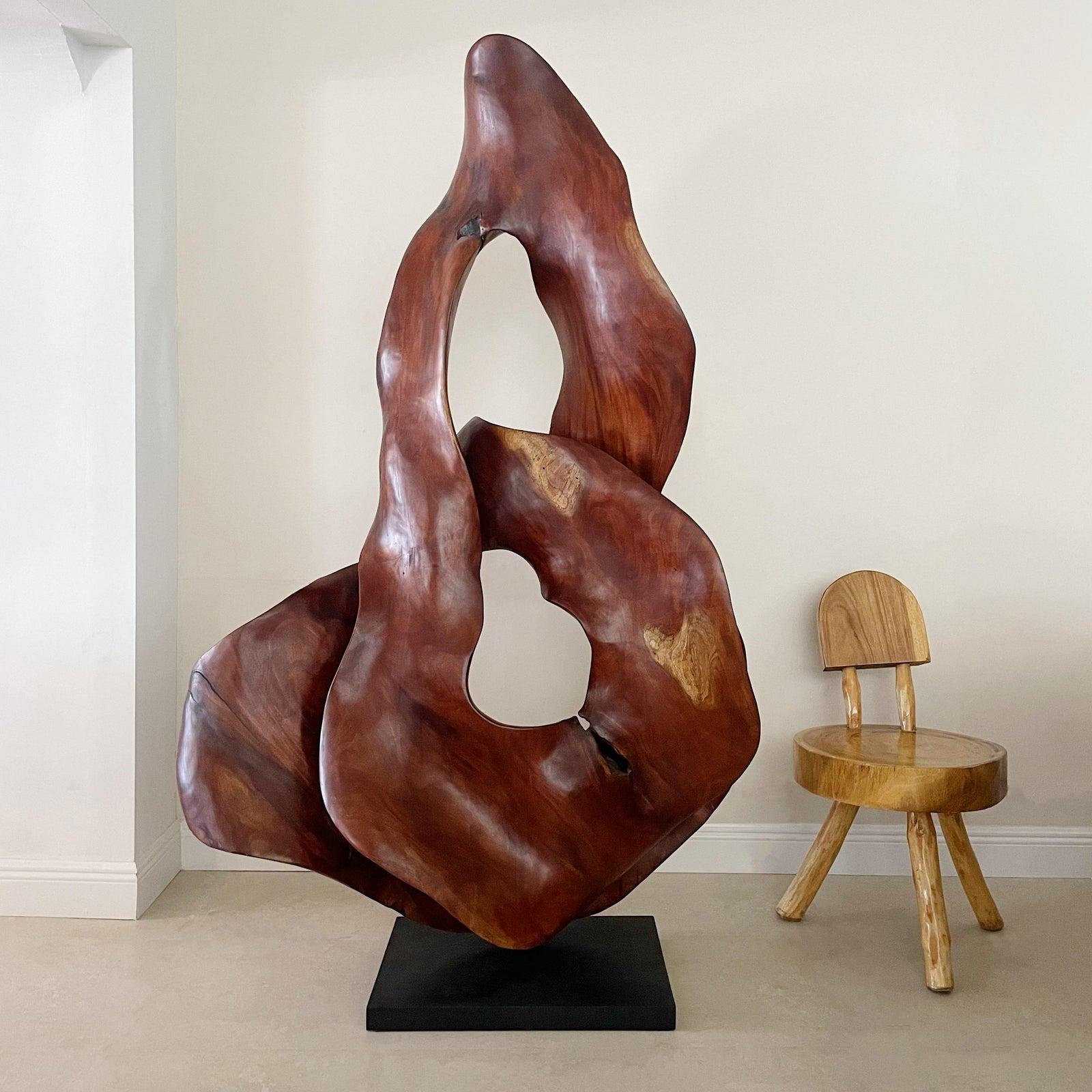 Large six and a half foot hand carved Brazilian exotic wood free form organic sculpture, in biomorphic form all carved from one piece of wood, supported on a black square wood base. 
This piece is stunning. 
Unsigned.