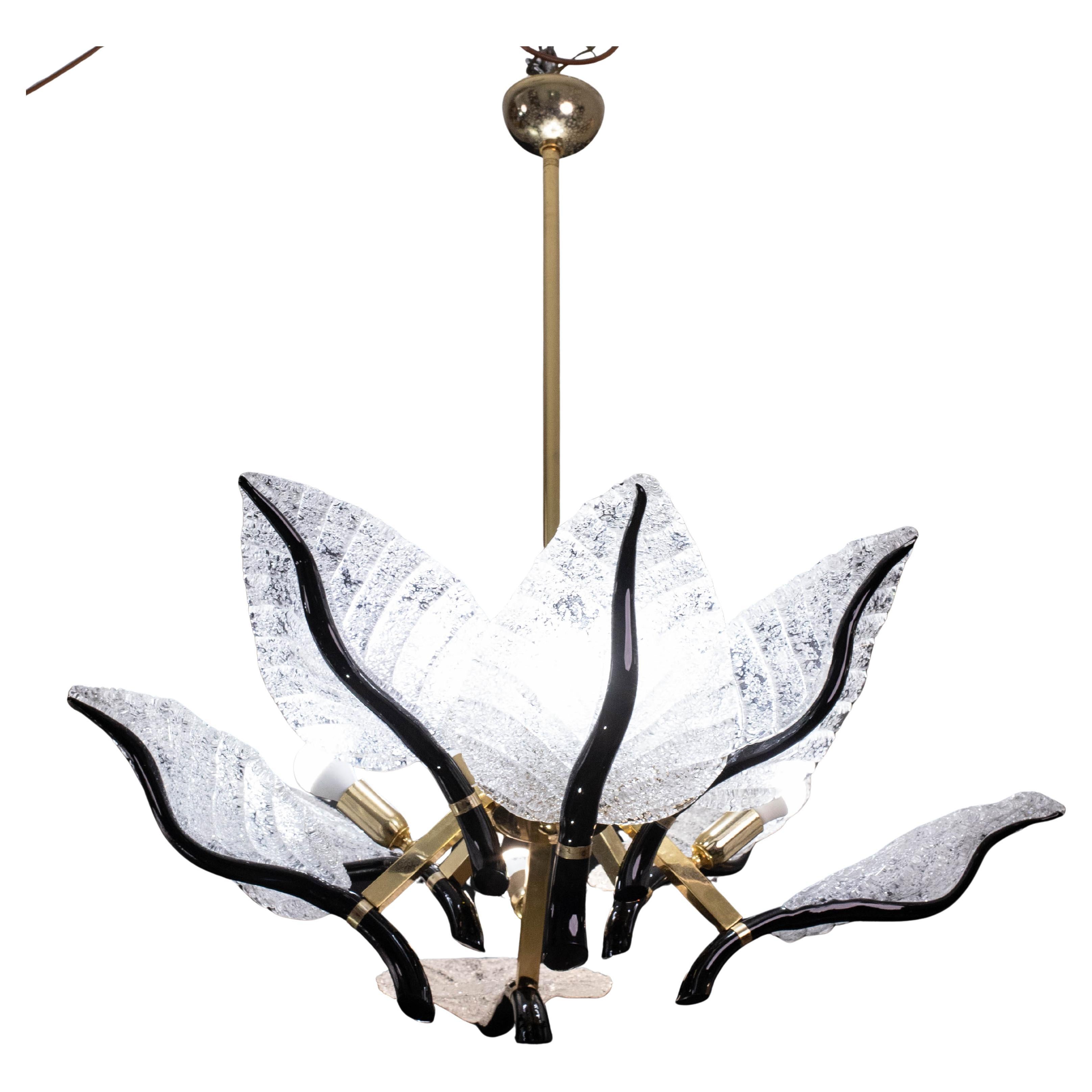 Prezioso lampadario di Murano con foglie in vetro soffiato a mano e ferramenta placcata in oro del famoso maestro designer Franco Luce.

Le otto foglie di vetro o otto code di gatto sono prive di scheggiature, crepe o riparazioni in un raro colore