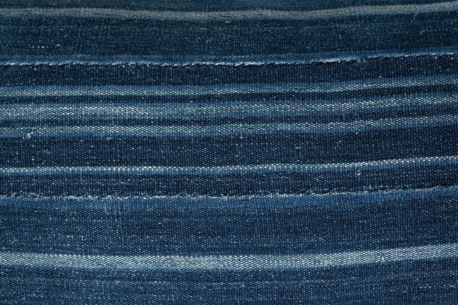 Large size faded indigo tone-on-tone stripe lumbar cushion made from vintage handwoven and hand-dyed slubby cotton fabric. Versatile tone-on-tone indigo stripe runs vertically on one face and is self-backed with same fabric running horizontally.