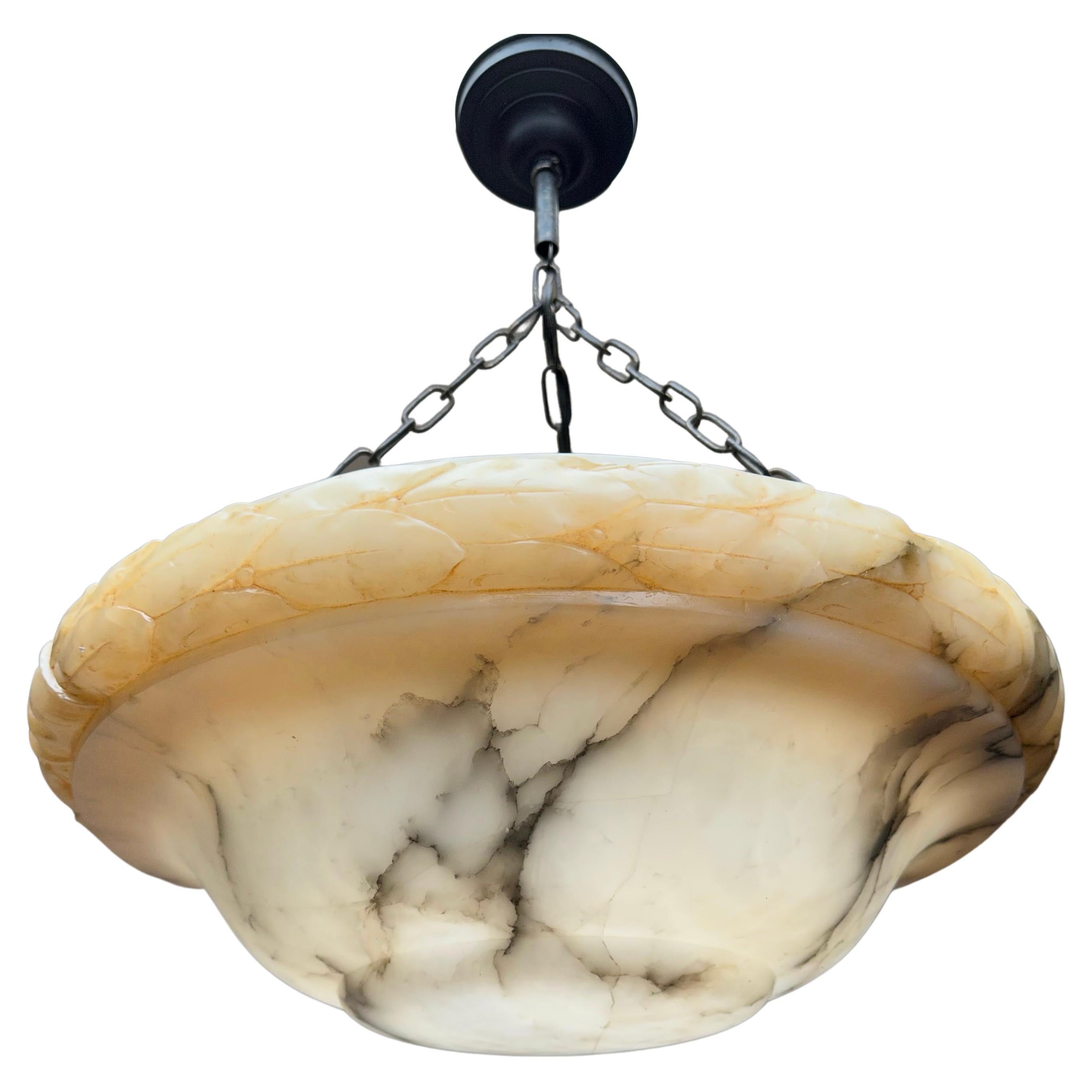 Suspension Art déco de grande classe avec un abat-jour en albâtre sculpté à la main avec de superbes veines et feuilles en tonnerre noir.

Grâce à sa grande taille et à son design élégant, ce lustre triple lumière en albâtre peut être utilisé et