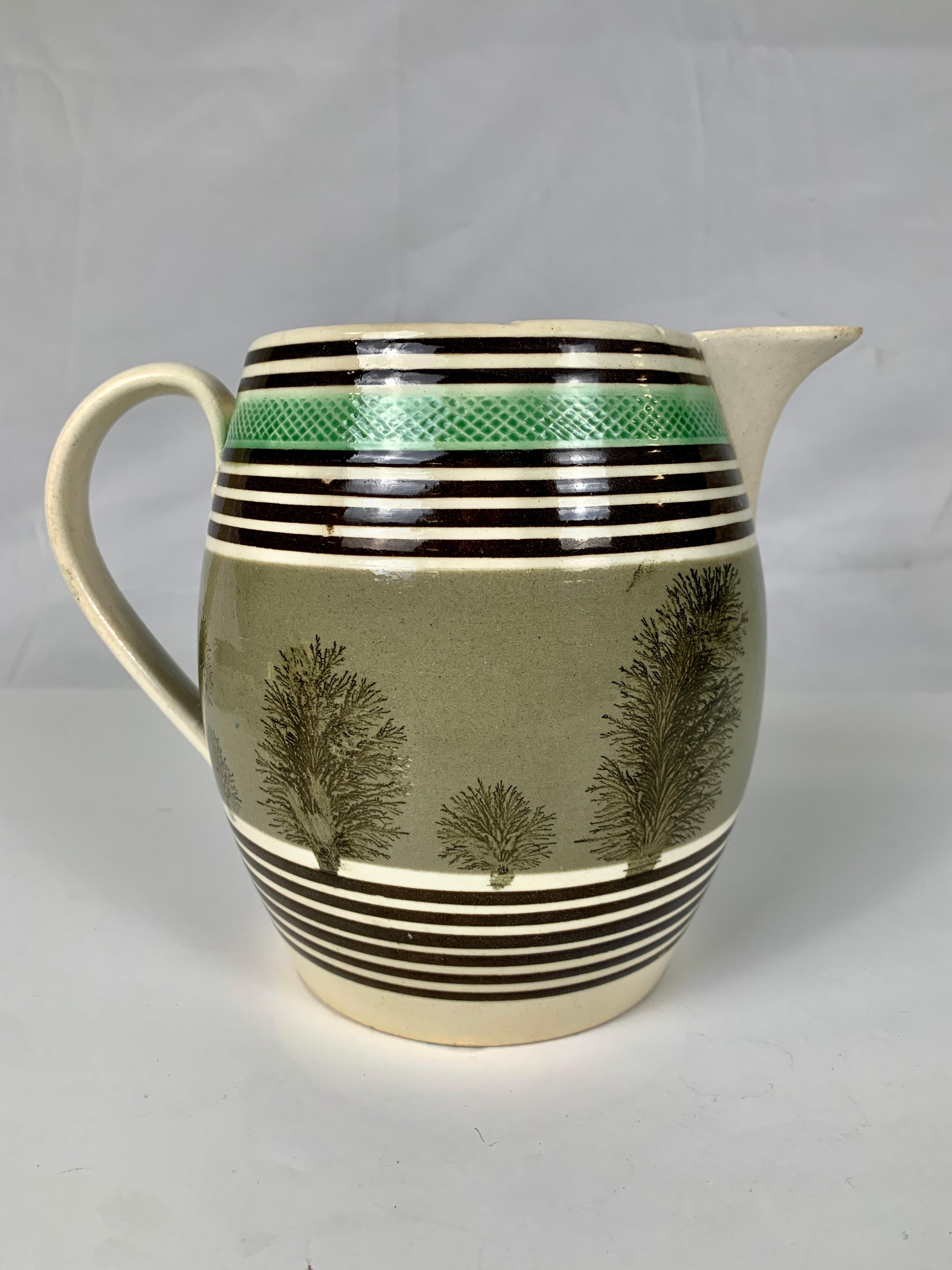This is the rare piece of mochaware that, intentionally or not, presents a scene. This large and beautiful mochaware pitcher is decorated with gray slip, the color of a stormy sky. A horizontal band of mocha 