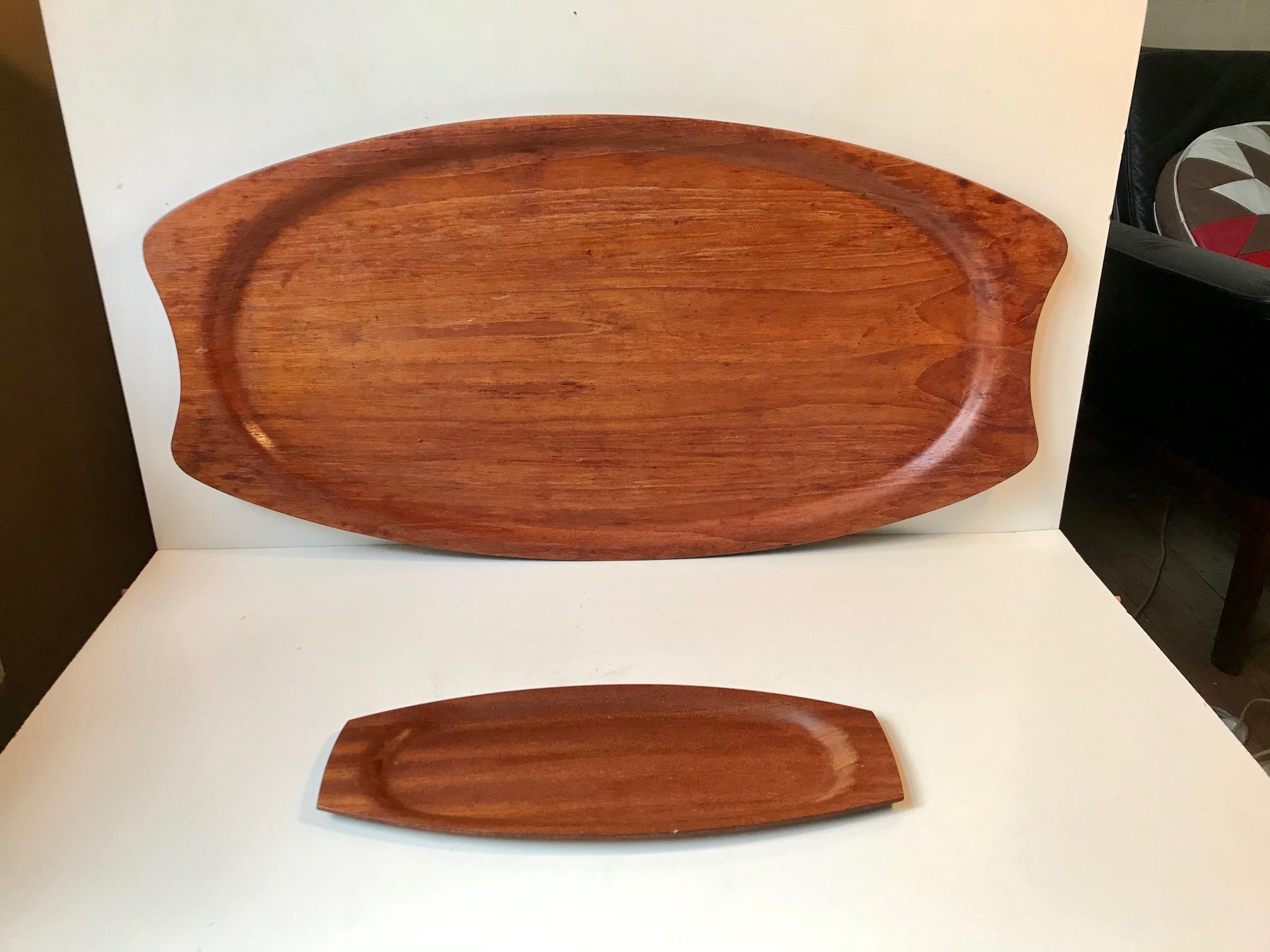 Large and small serving trays made from teak veneer. Suitable as a bed serving set due to its size and raised edges. It was made in Denmark during the 1960s by Silva. The small tray measures: 32 x 13 cm. The measurements below are for there large