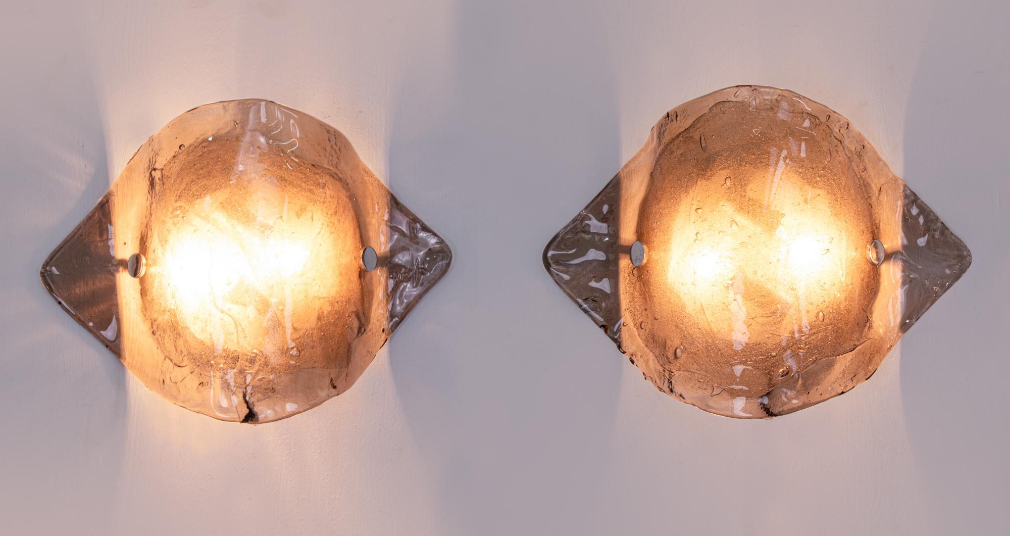 Elegant pair of Kalmar wall sconces made of handblown smoked / amber Murano glass mounted on white back plates. Made in Austria in the 1960s. 

Design: Carlo Nason attr. 
Maker: J.T. Kalmar, labeled. 
Measures: height 11.8“ in. (30 cm), width 17“