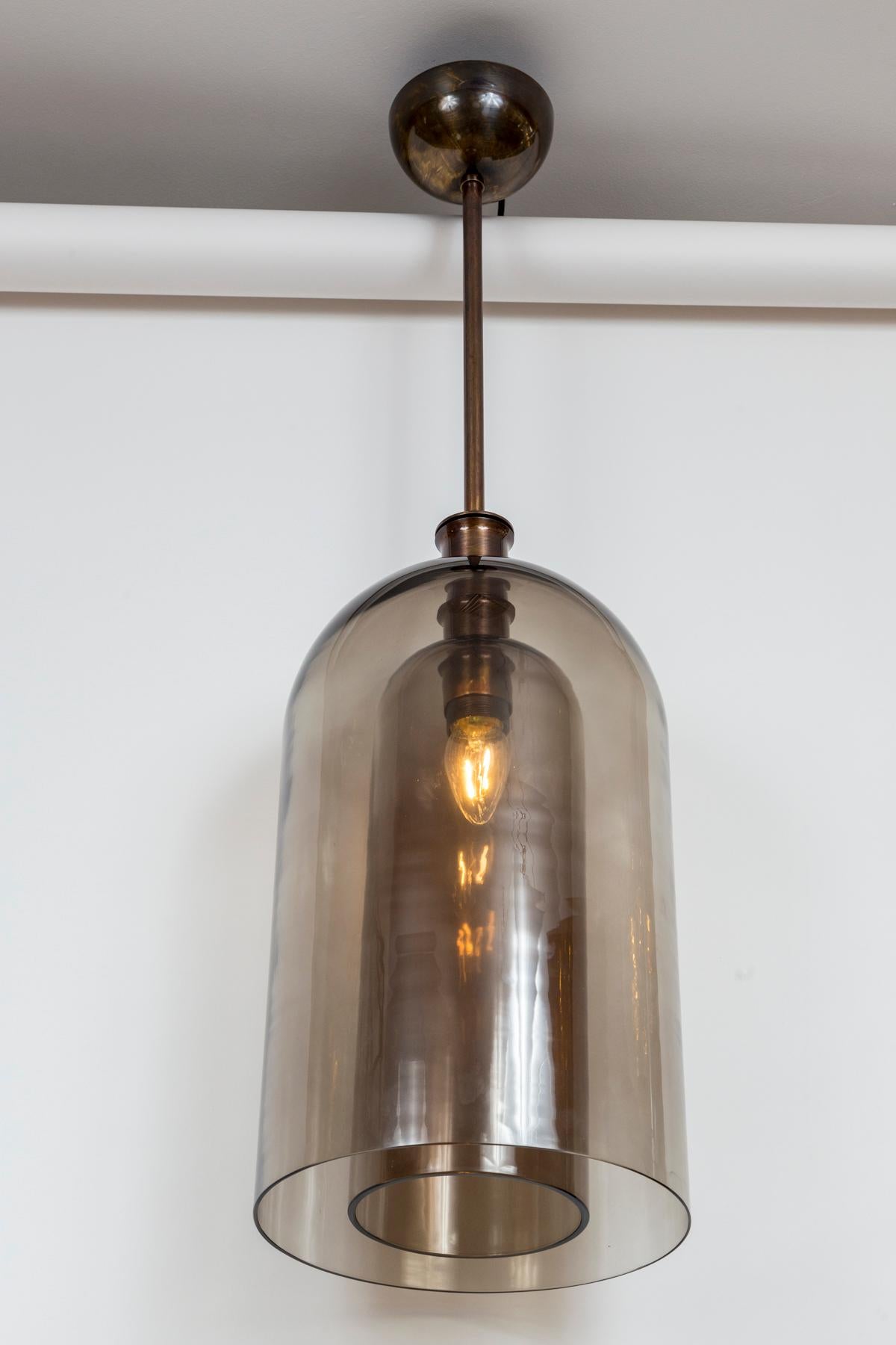 Pendentif en verre soufflé à la bouche à deux couches, la plus grande forme en verre de couleur fumée, la plus petite forme dans un brun grège. Notez l'ondulation du verre, qui ressemble à du cristal fin, car il n'a pas été placé dans un moule mais