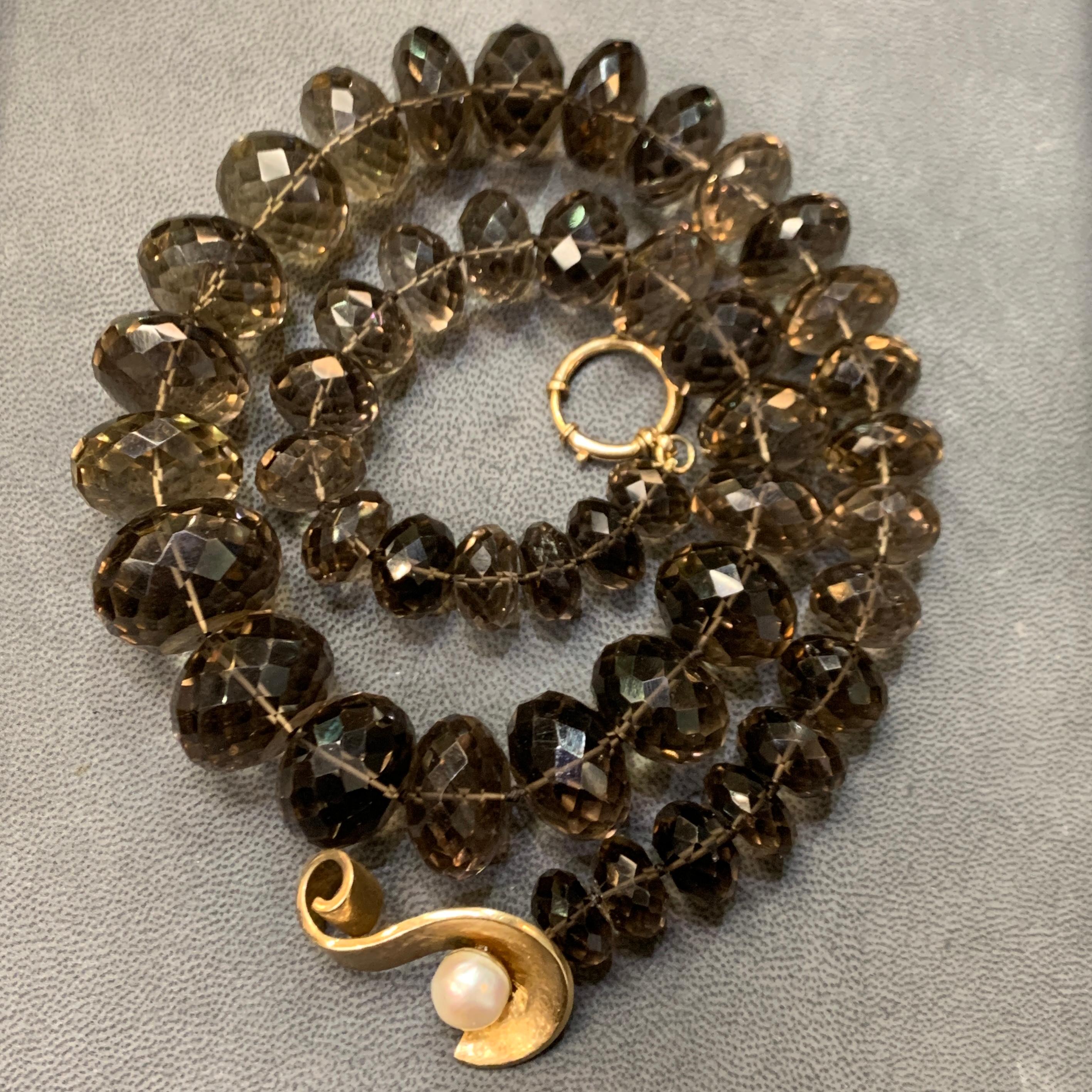 Large Graduated Smokey Quartz Bead Necklace

A strand necklace featuring multiple sizes of 45 smokey quartz beads graduating from small to large beads. This necklace also includes a 14 karat yellow gold clasp with a cultured pearl in the