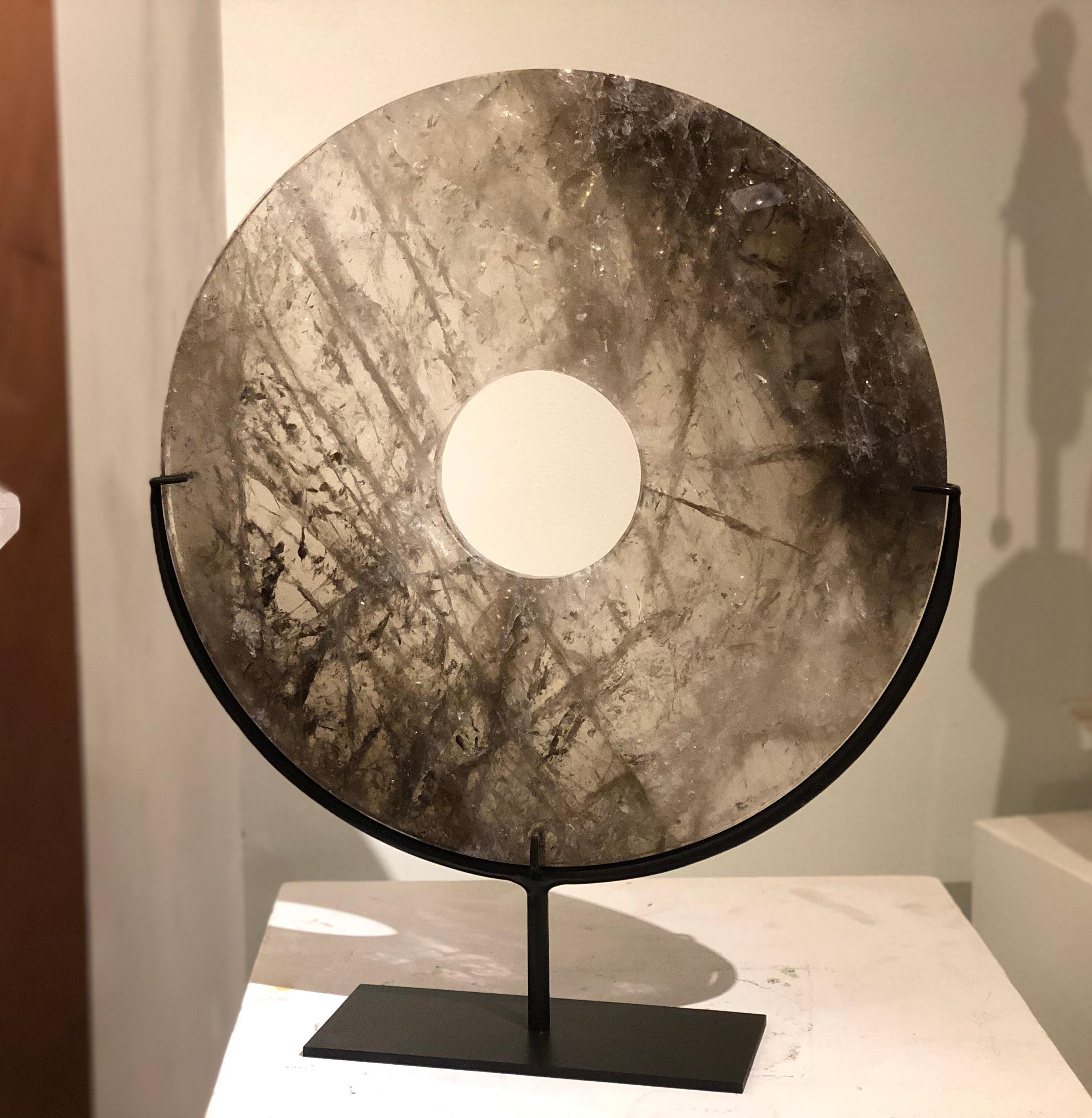 A large smoky-grey rock crystal quartz disk with beautiful natural veins.
 