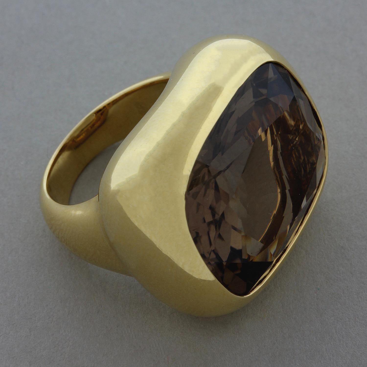 A simple yet over the top cocktail ring featuring a 22.57 carat smoky quartz. The cushion cut smoky quartz is bezel set in an 18K yellow gold setting. A bold ring that will surely impress.

Ring Size 6.5 (Sizable)
