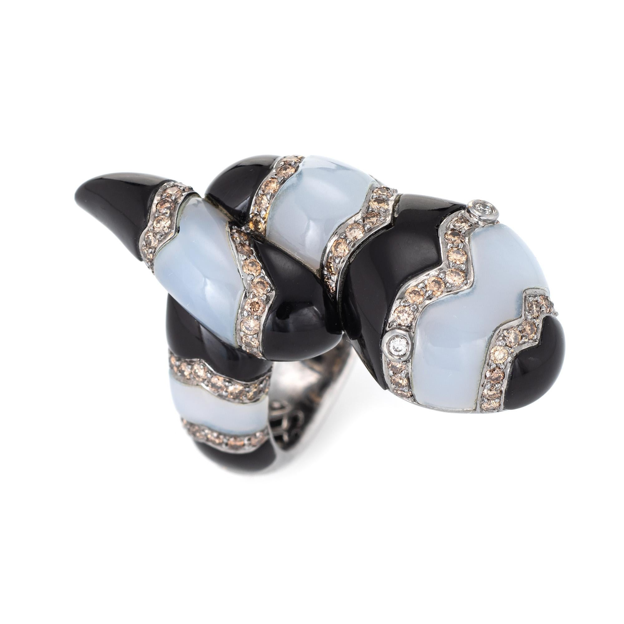 Large snake ring set with black onyx, white chalcedony and diamonds crafted in 18 karat white gold. 

Diamonds total an estimated 1.25 carats (estimated at L-M color and SI1-2 clarity). Black onyx and milky white chalcedony are inlaid into the