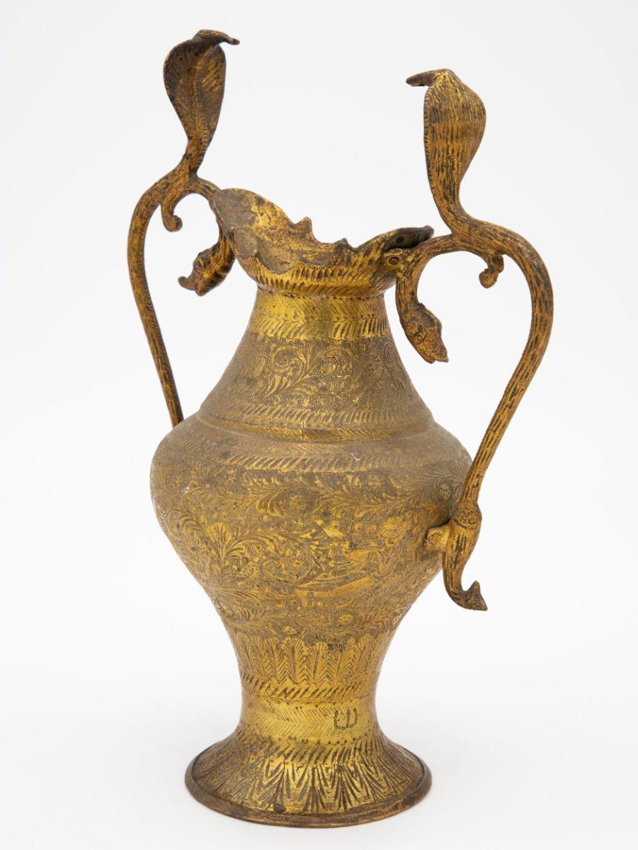 An etched brass vase with two handles in the shape of Cobras. The exquisitely etched surface has multiple repeating patterns. An early 20th Century Moroccan piece, this decorative vase would likely have been a wonderful travel memento.