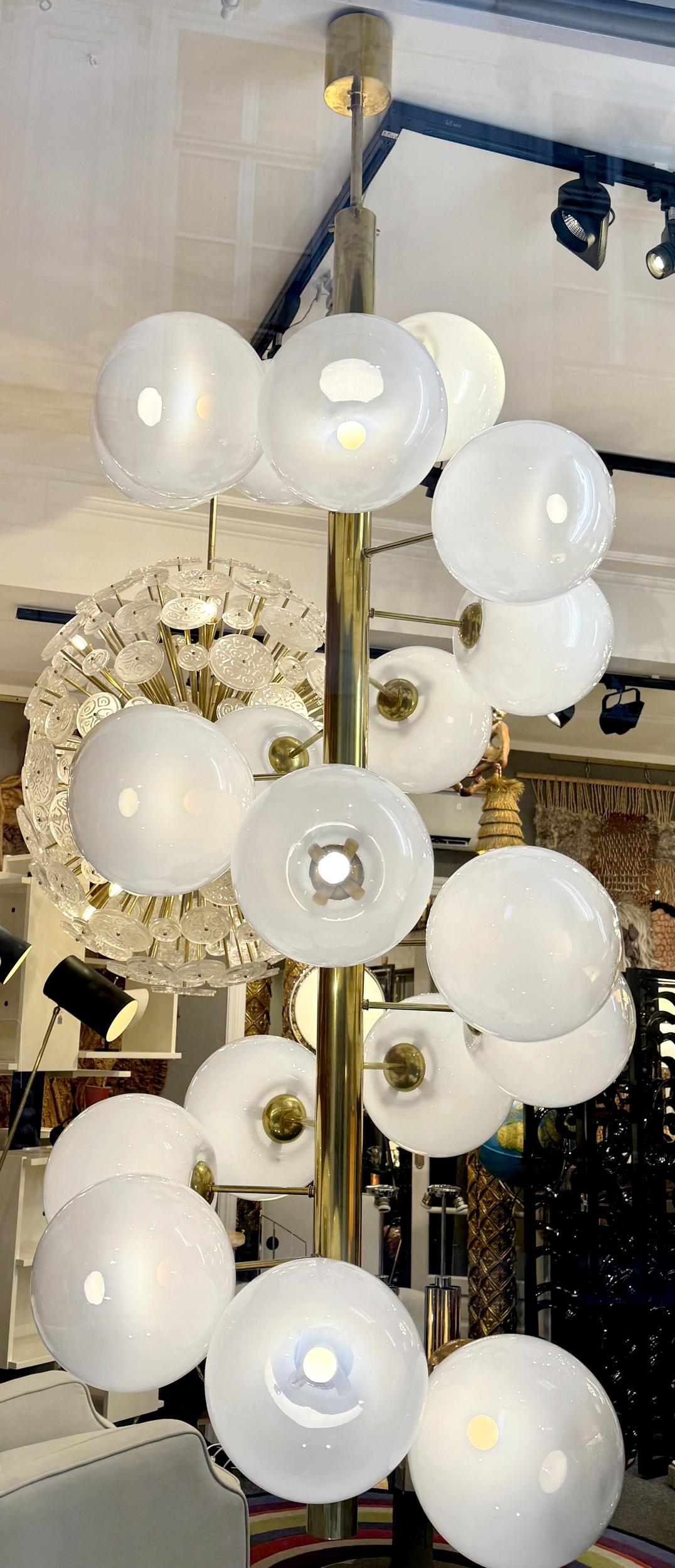 Lampadario molto grande composto da un'asta rotonda in ottone lucido su cui sono montati venti globi di vetro Vistosi degli anni '80 in una gradazione di colori dal bianco al trasparente.
Artigianato moderno.

Per la spedizione, ci sono 11 scatole