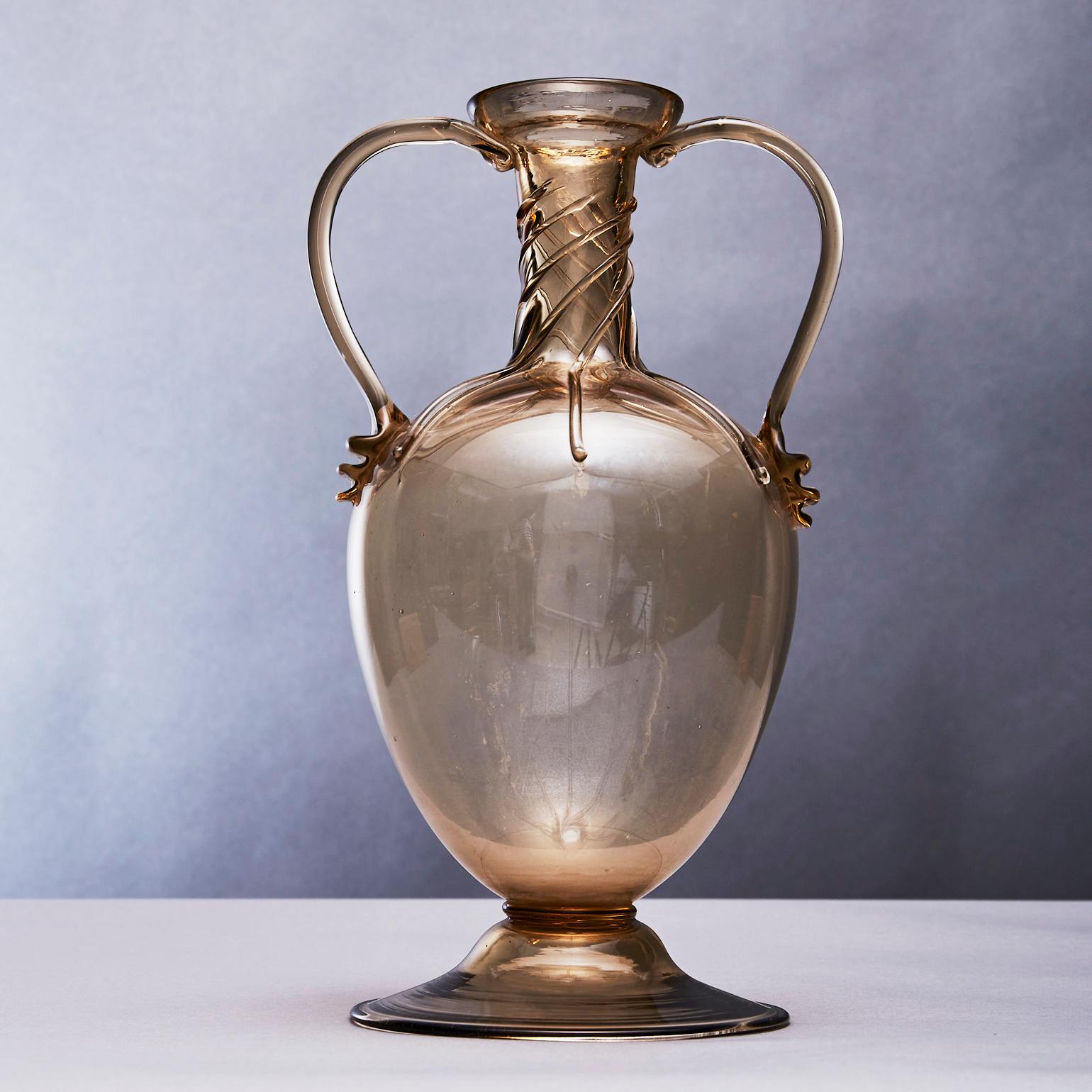 Le vase Soffiato à double anse est attribué à Vittorio Zecchin (1878-1947), qui a laissé une empreinte durable sur le verre du XXe siècle. Les producteurs MVM Cappellin étaient l'une des entreprises les plus importantes pour le verre italien. La