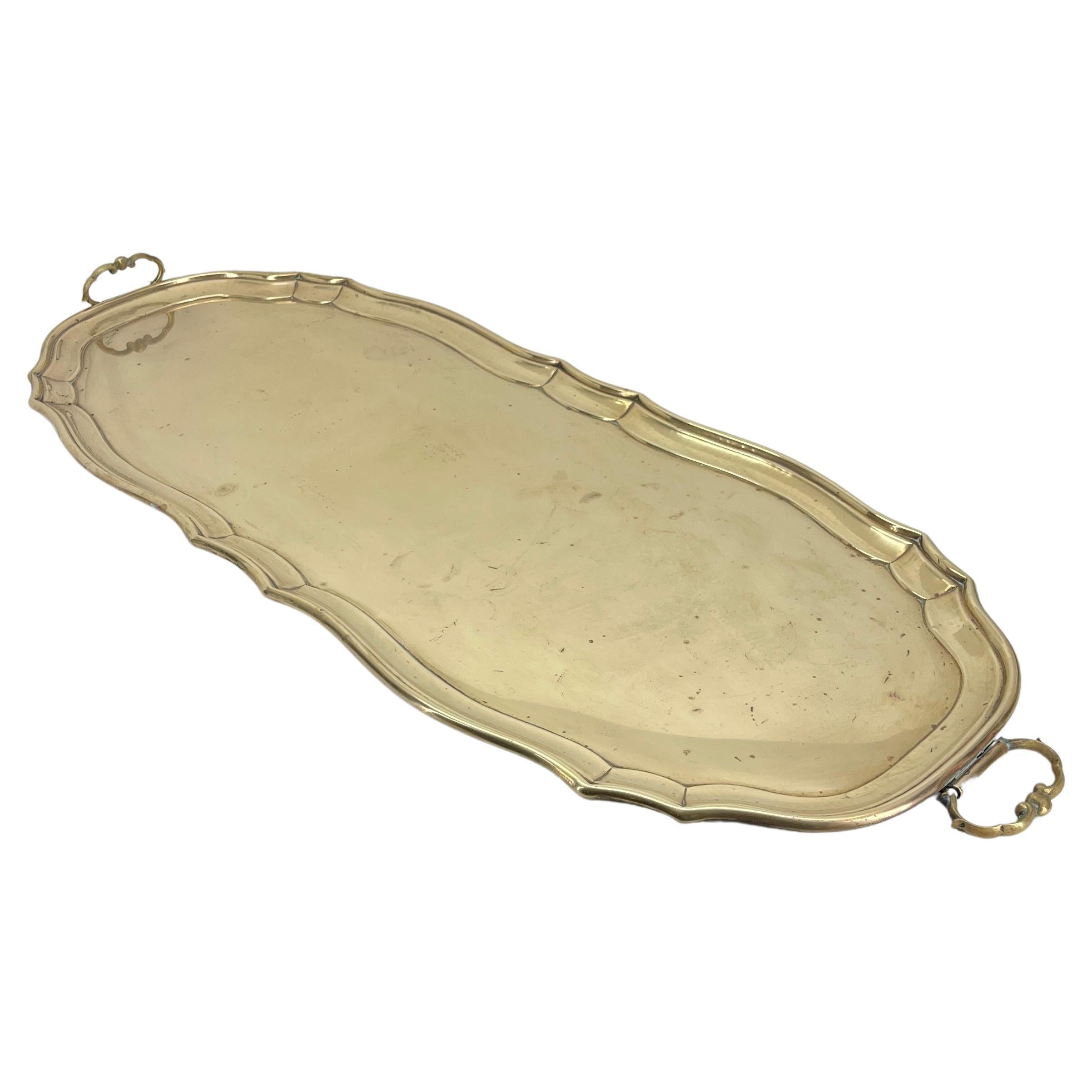 Long narrow heavy brass tray with bronze handles, marked made in Germany. 
This amazing tray is quite long and can easily be used for as a centerpiece on a dining table. The tray has been used by legendary New York City based interior designer and