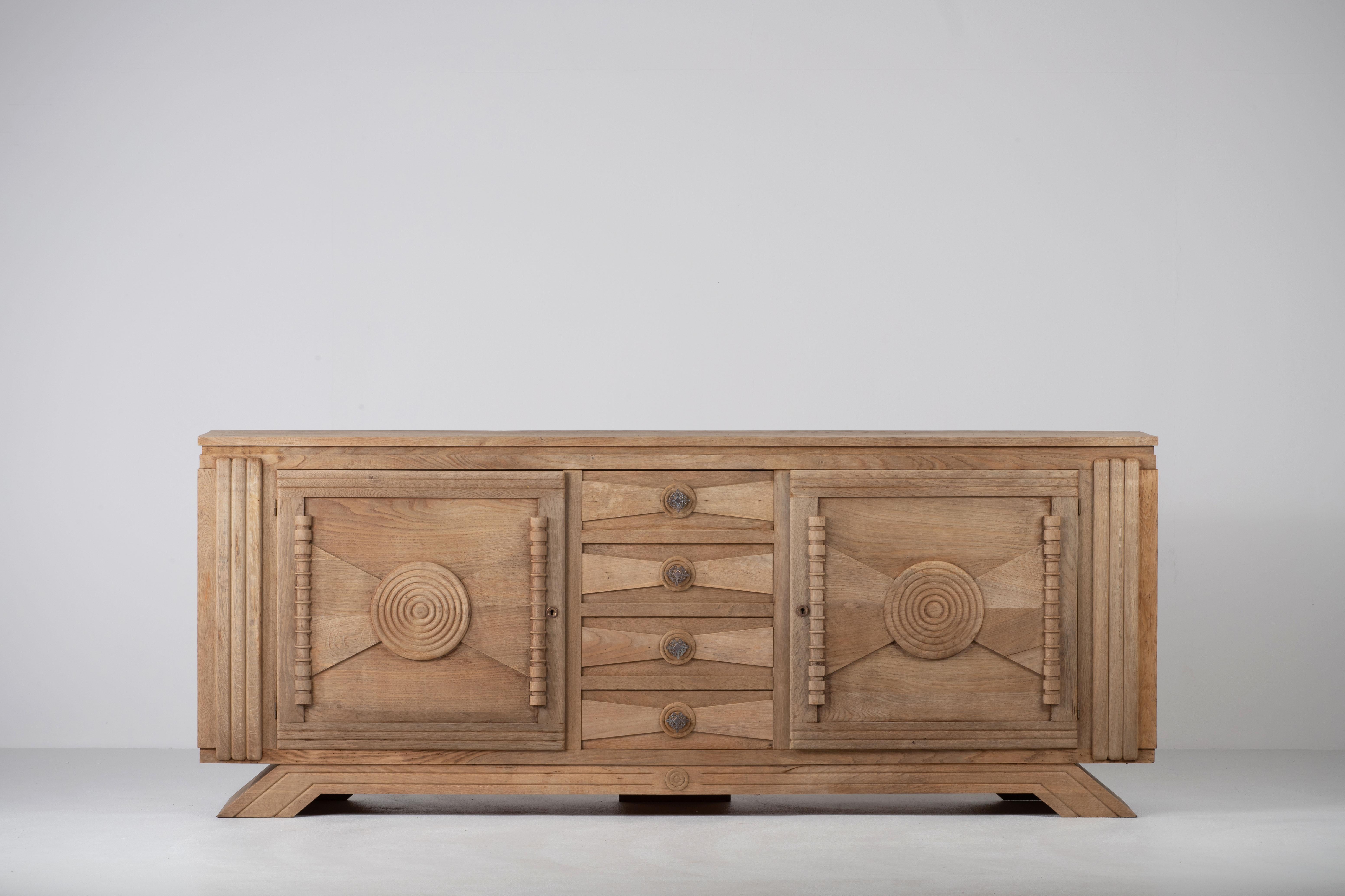 Credenza, solid oak, France, attributed to Charles Dudouyt, 1940s.
Large Art Deco Brutalist sideboard. 
The credenza consists of three central drawers and three storage facilities and covered with very detailed designed doors. 
The refined wooden