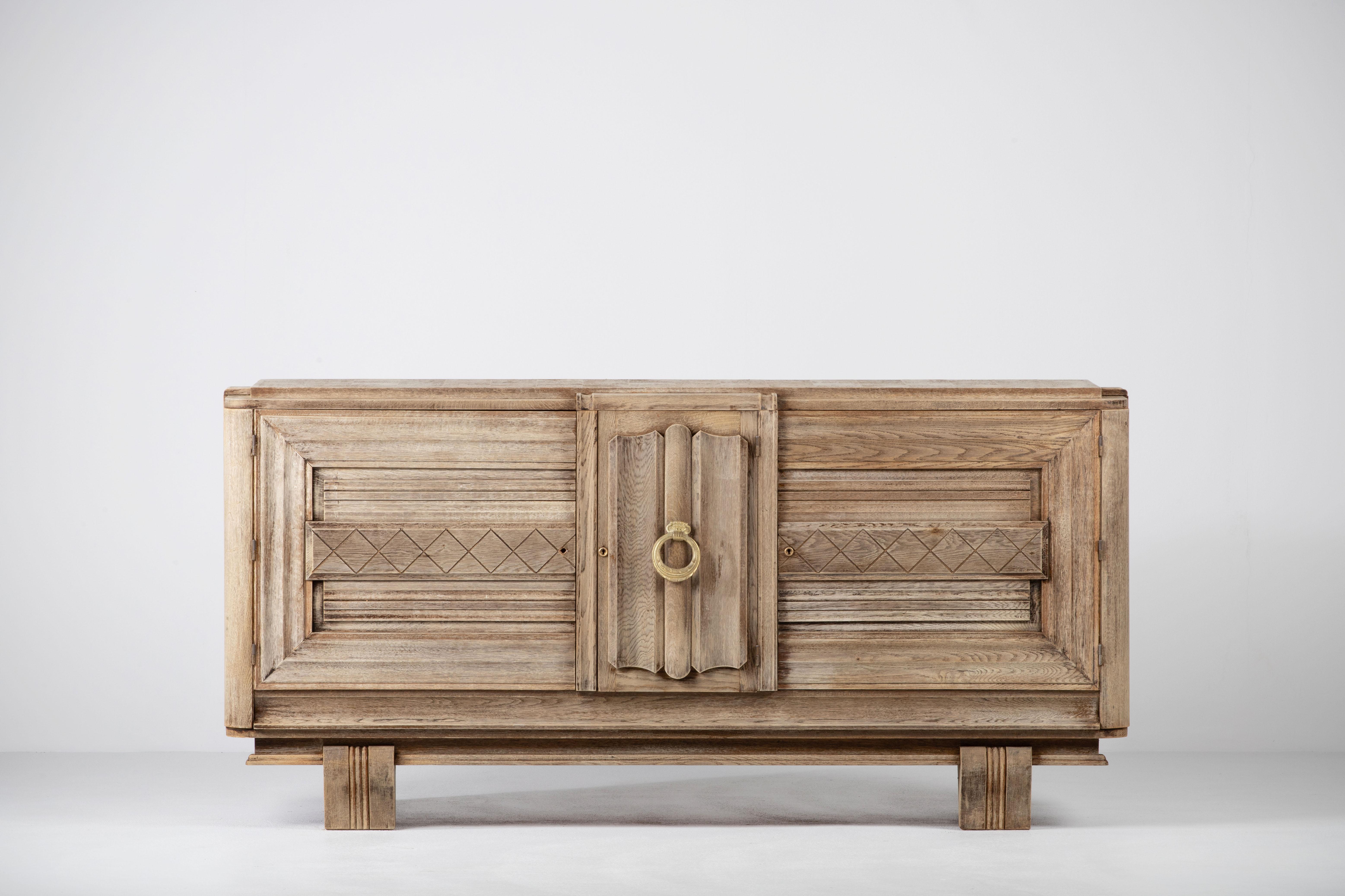 Credenza, solid oak, France, 1940s.
Large Art Deco Brutalist sideboard. 
The credenza consists of three storage facilities and covered with very detailed designed doors. 
The refined wooden structures on the doors create a striking combination