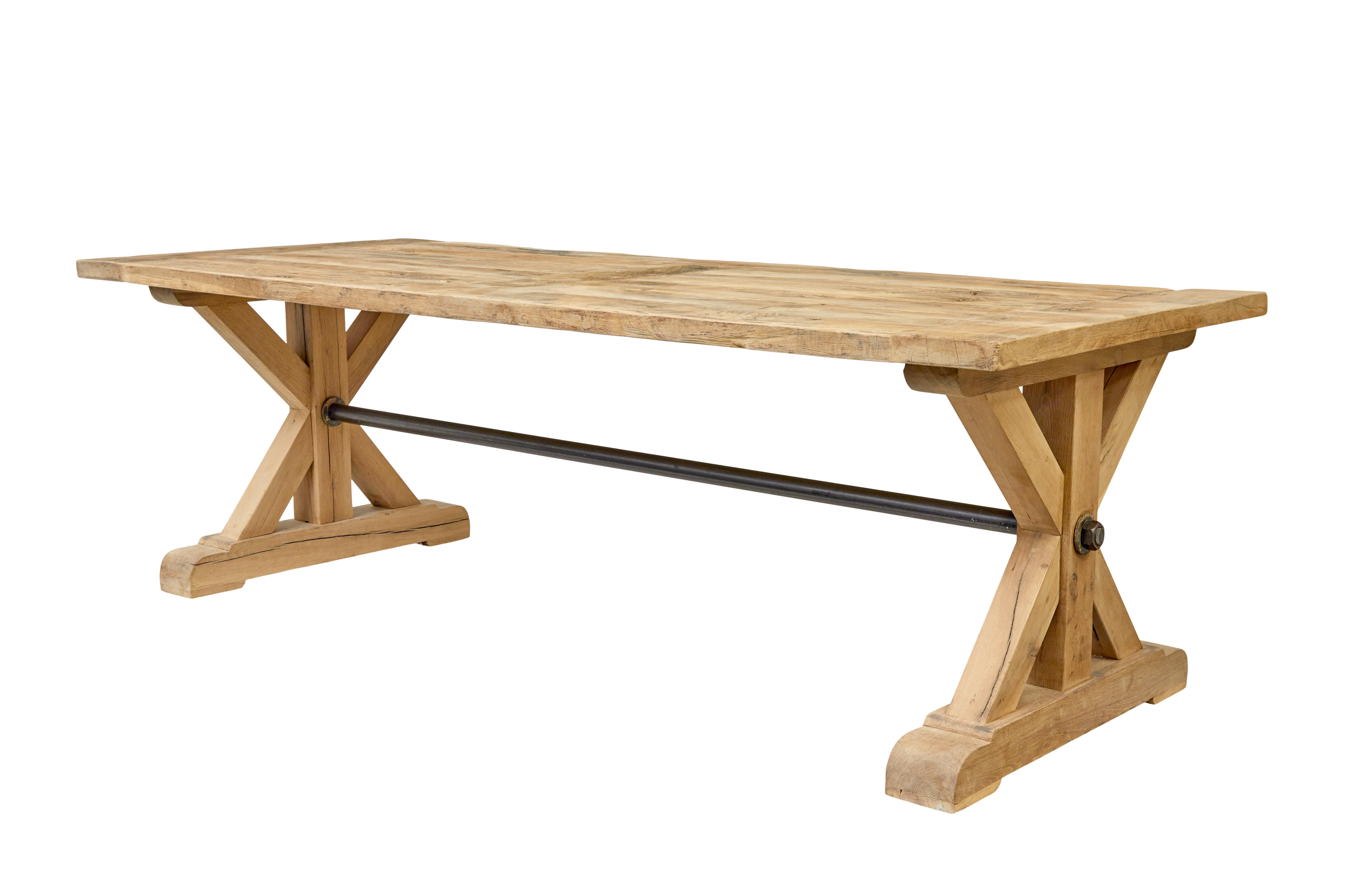 Here we have a substantial dining table made from solid oak.

Capable of seating a comfortable 10.  Oak top made from reclaimed timbers with cleated ends.  Standing on x frame trestle ends united by iron tubular stretcher.

Terminating on sledge