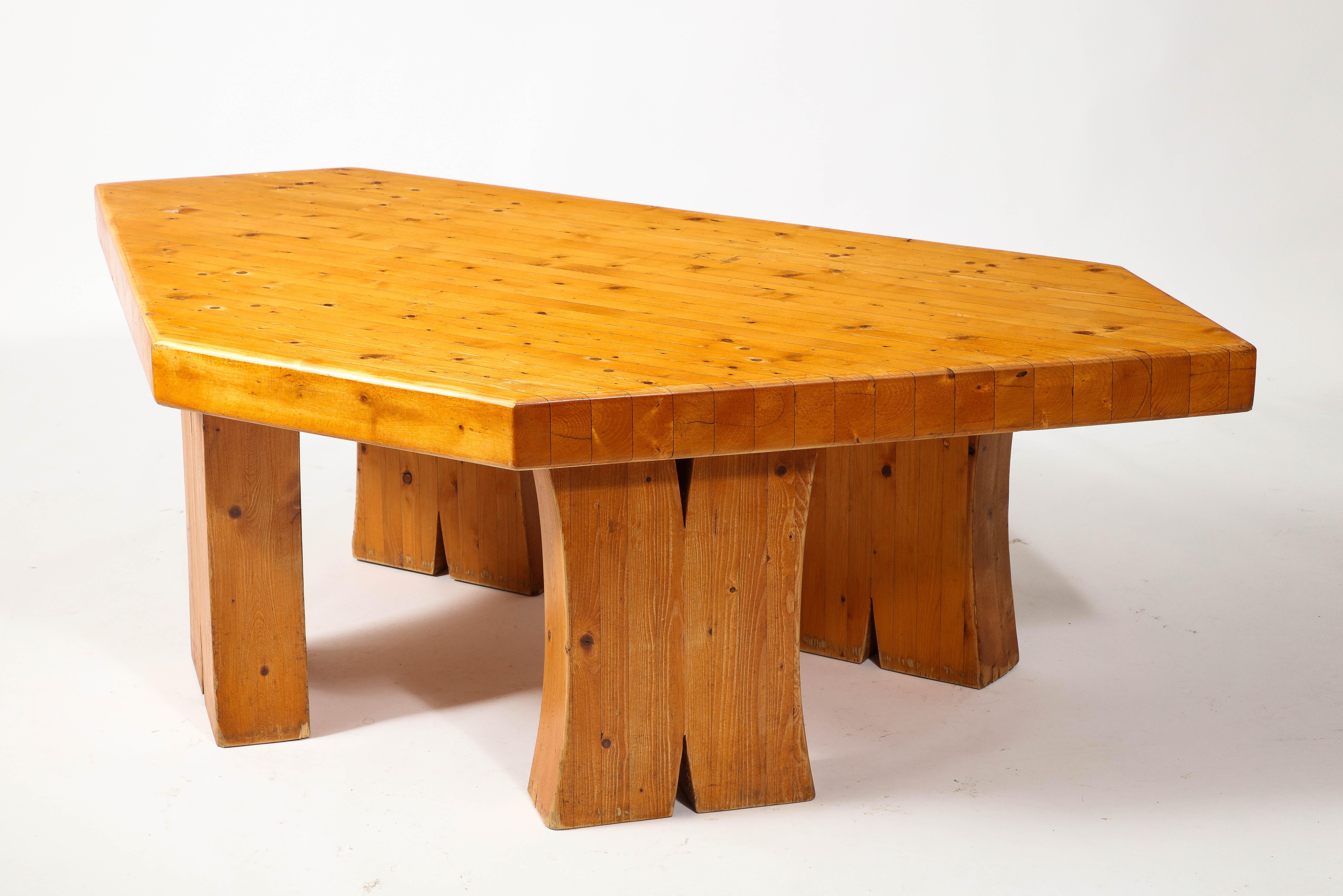 Exceptionally large solid pine table constructed in laminated planks with a thick top at almost three inches thickness. This rests on equally massive legs that end in a bifurcation. Most likely a unique studio piece. Original finish and patina.